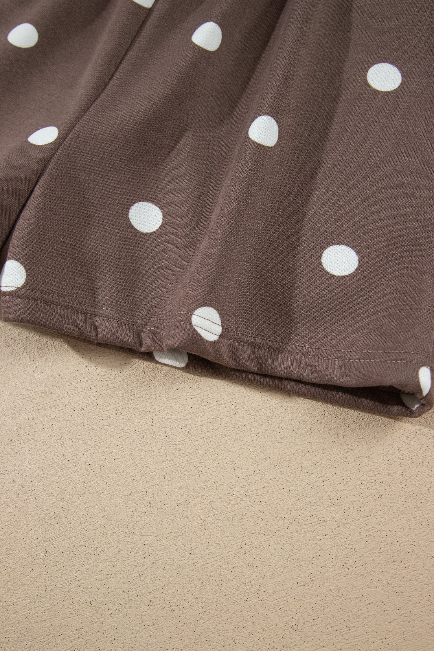 Hem detail of brown polka dot shorts