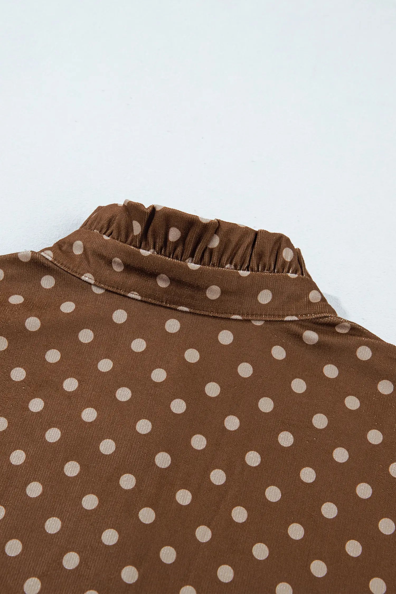 Detail view of brown and cream polka dot shift dress