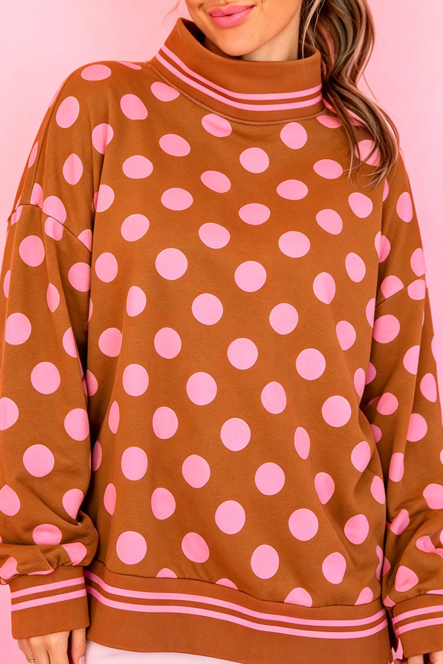 Brown mock neck sweatshirt with pink polka dots and striped trim, front view
