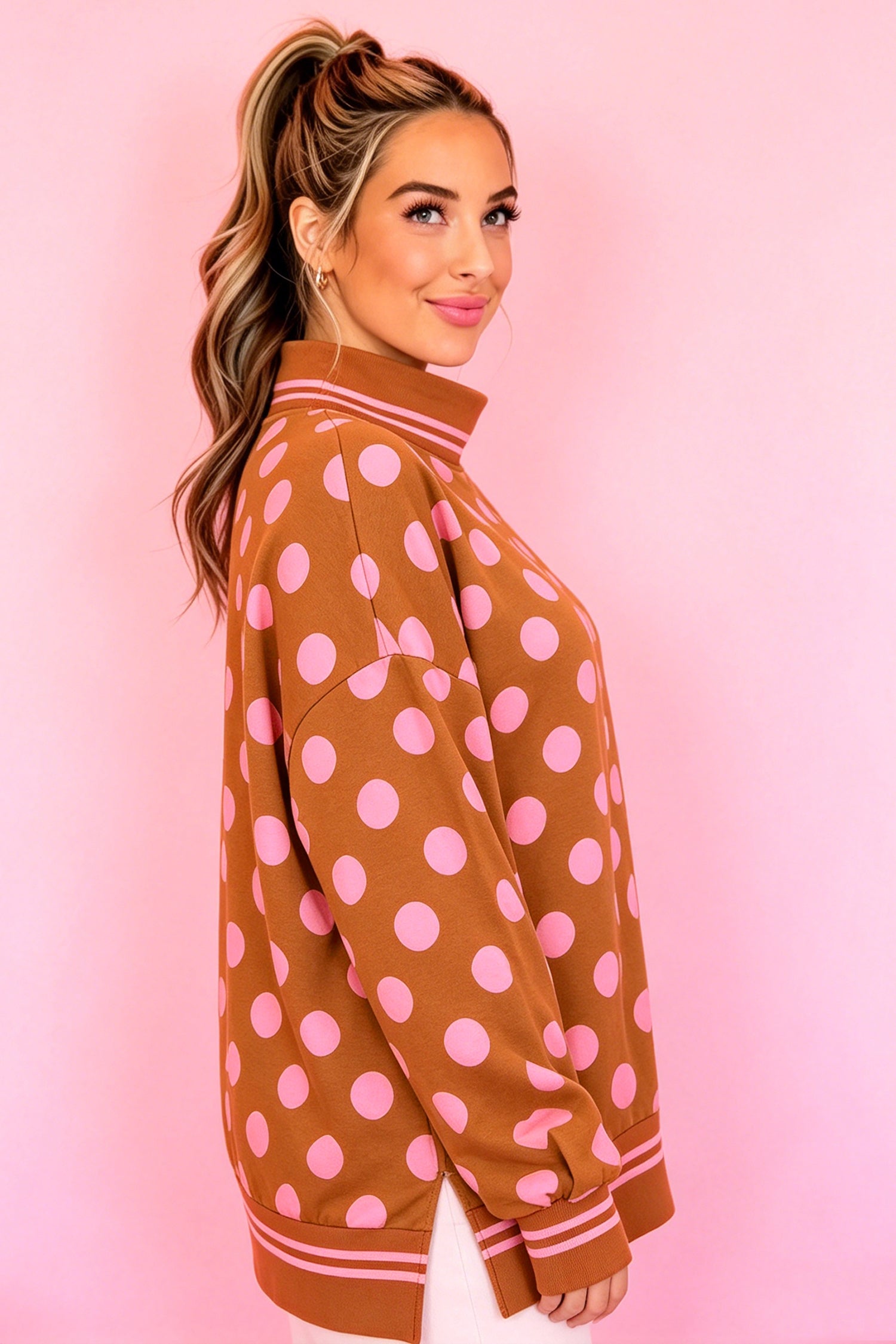 Side view of brown polka dot mock neck sweatshirt with striped hem band