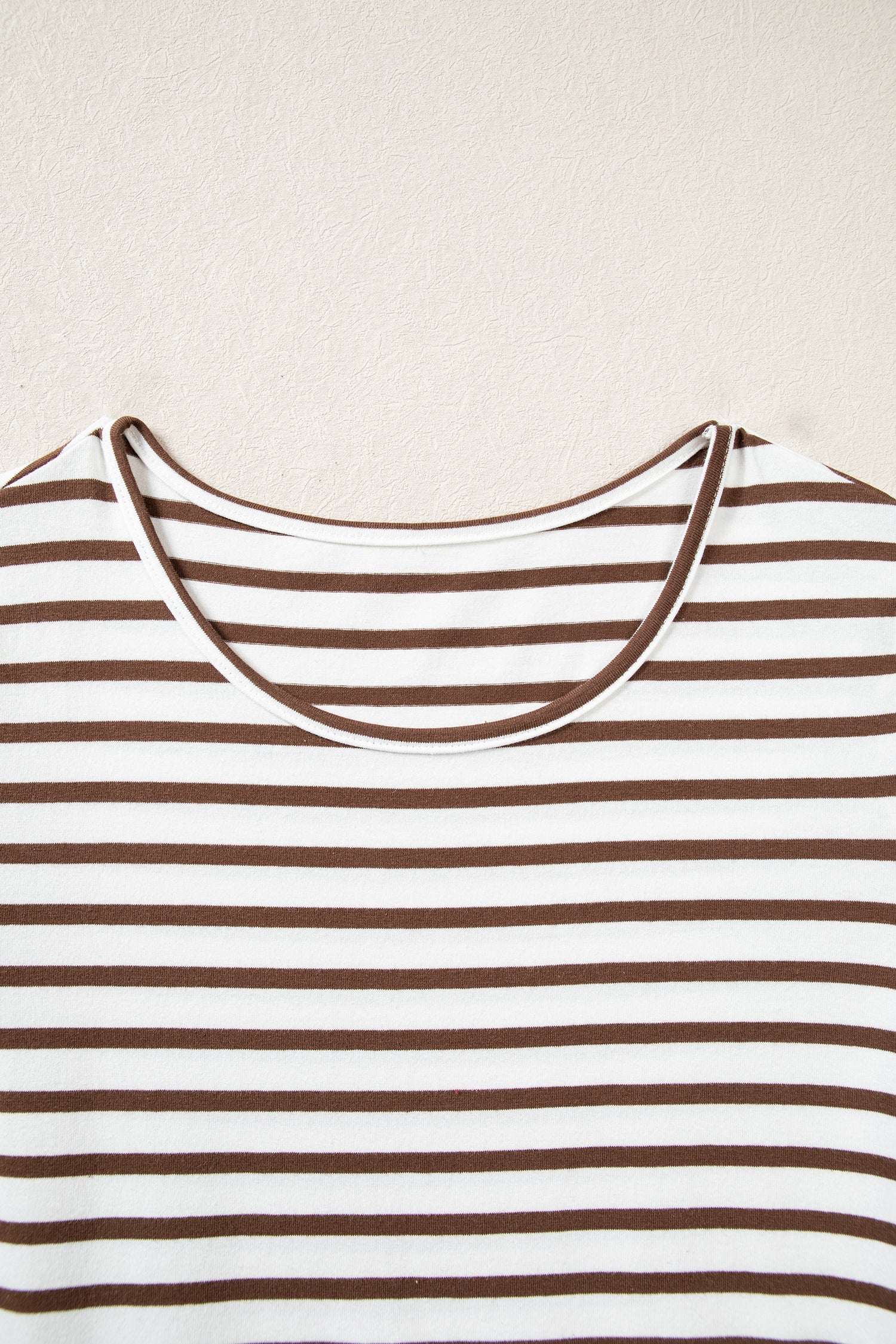 Round neckline on the white and brown striped ribbed bodice