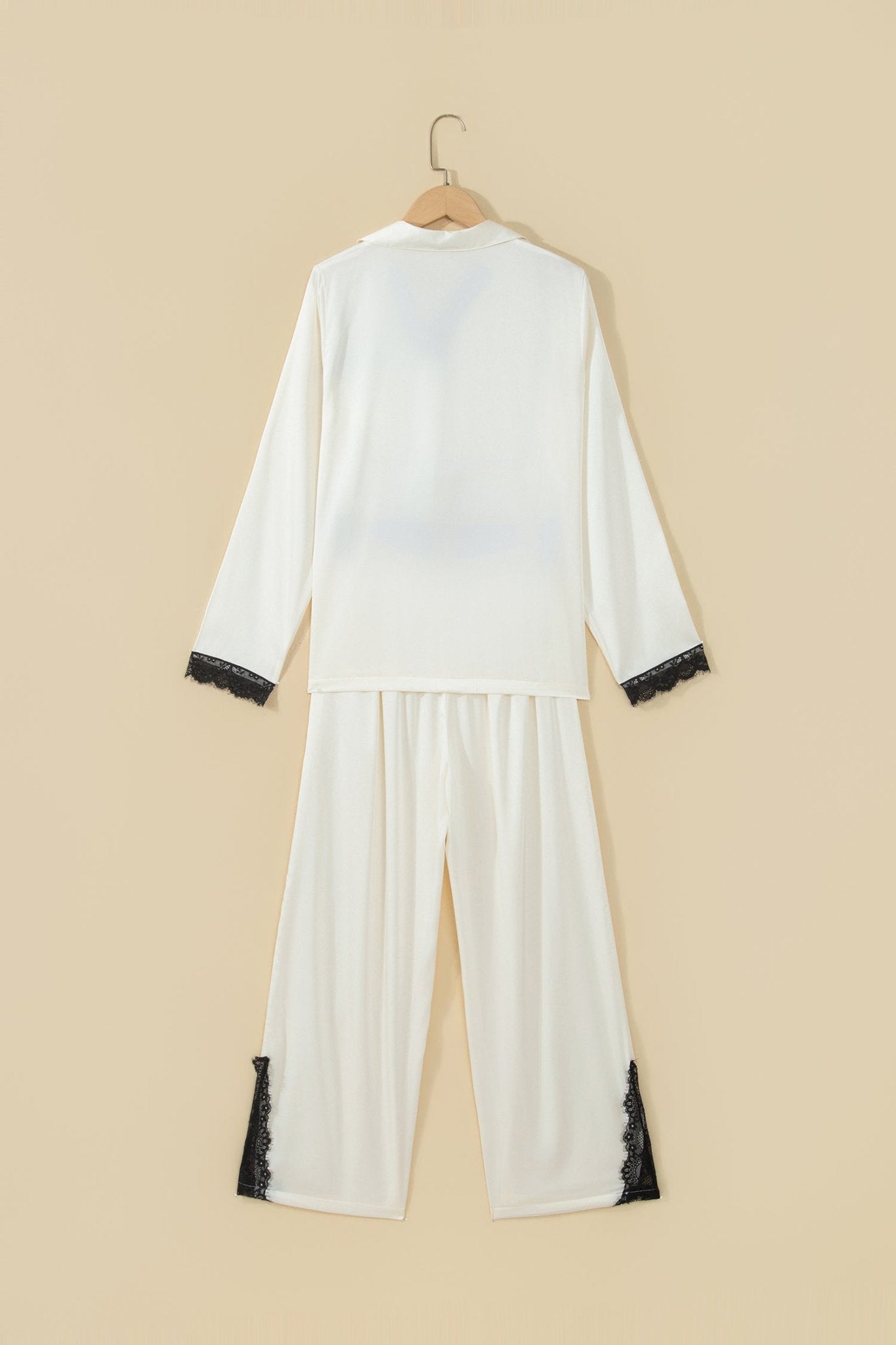 White pajama set with black lace trim on cuffs and hem.