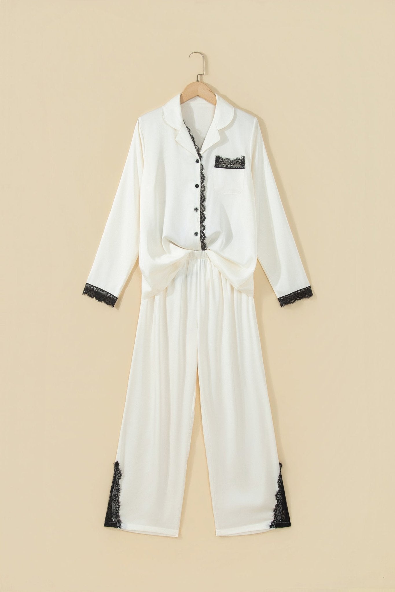 White pajama set with black lace trim on hanger.