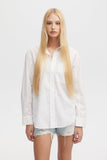 Person wearing a white shirt and denim shorts on a plain background