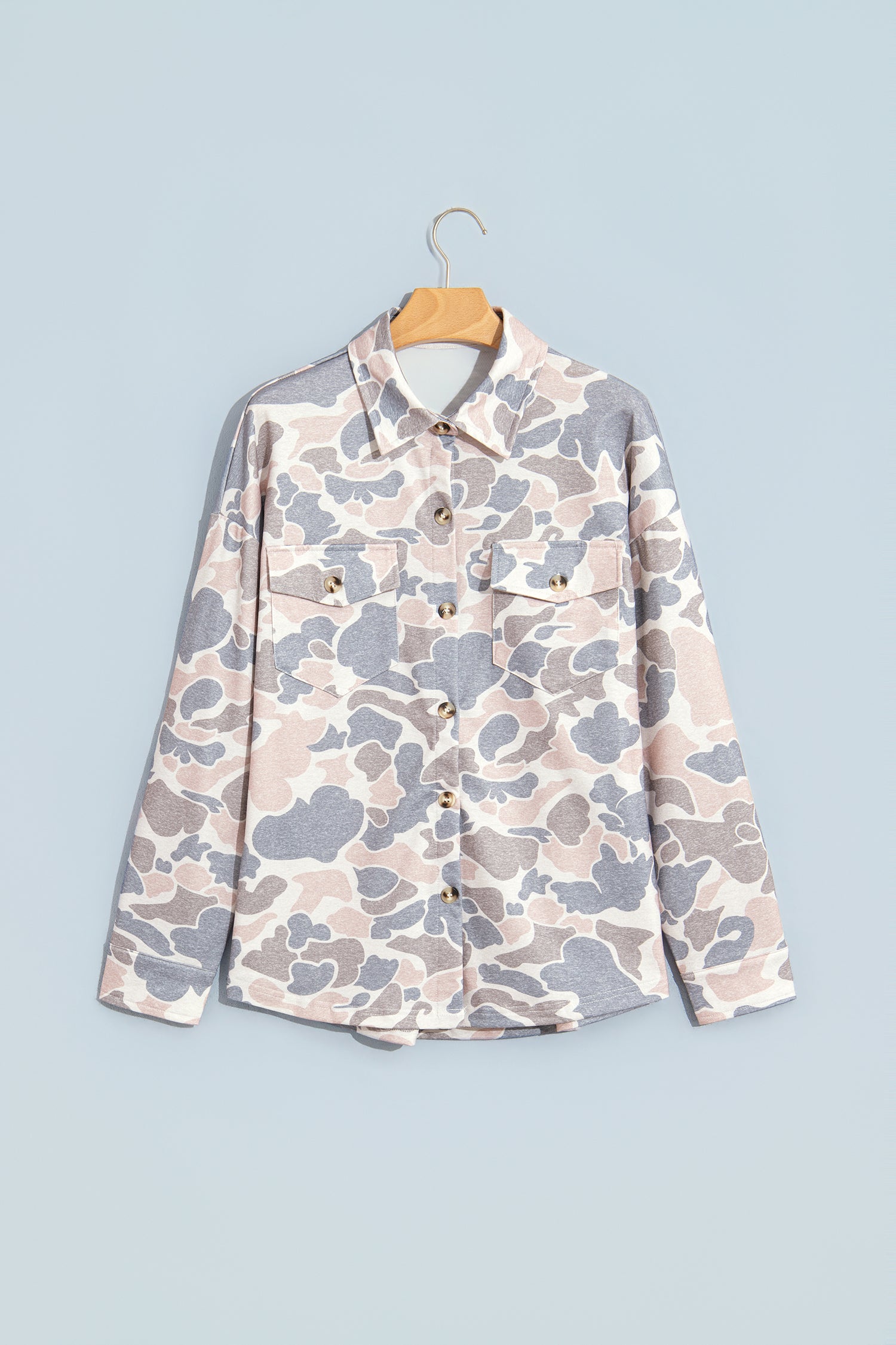 Pink and grey camo button down tunic shacket on a hanger, front view