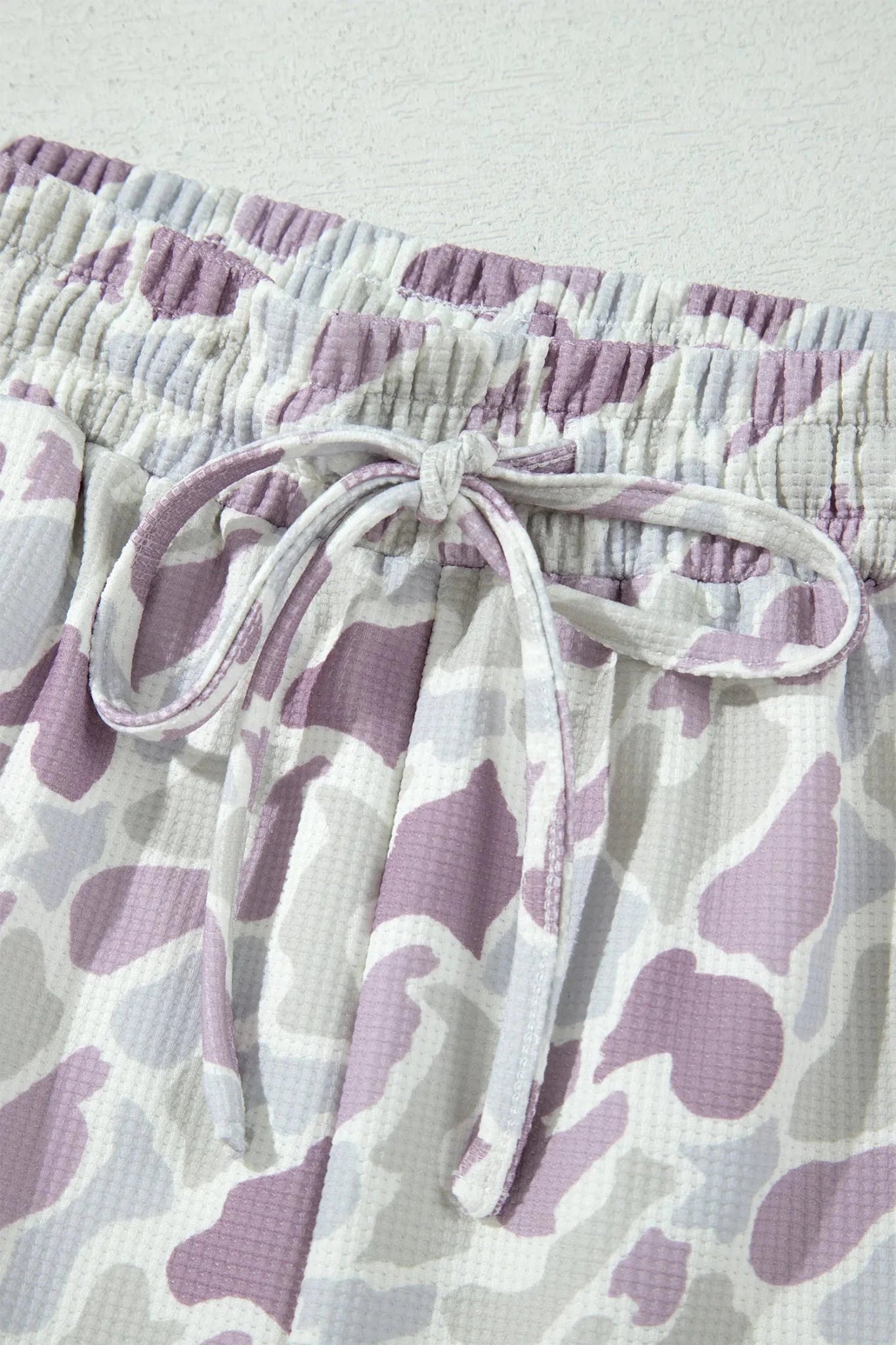 Purple and gray waffle-textured cow-print shorts with drawstring waist.