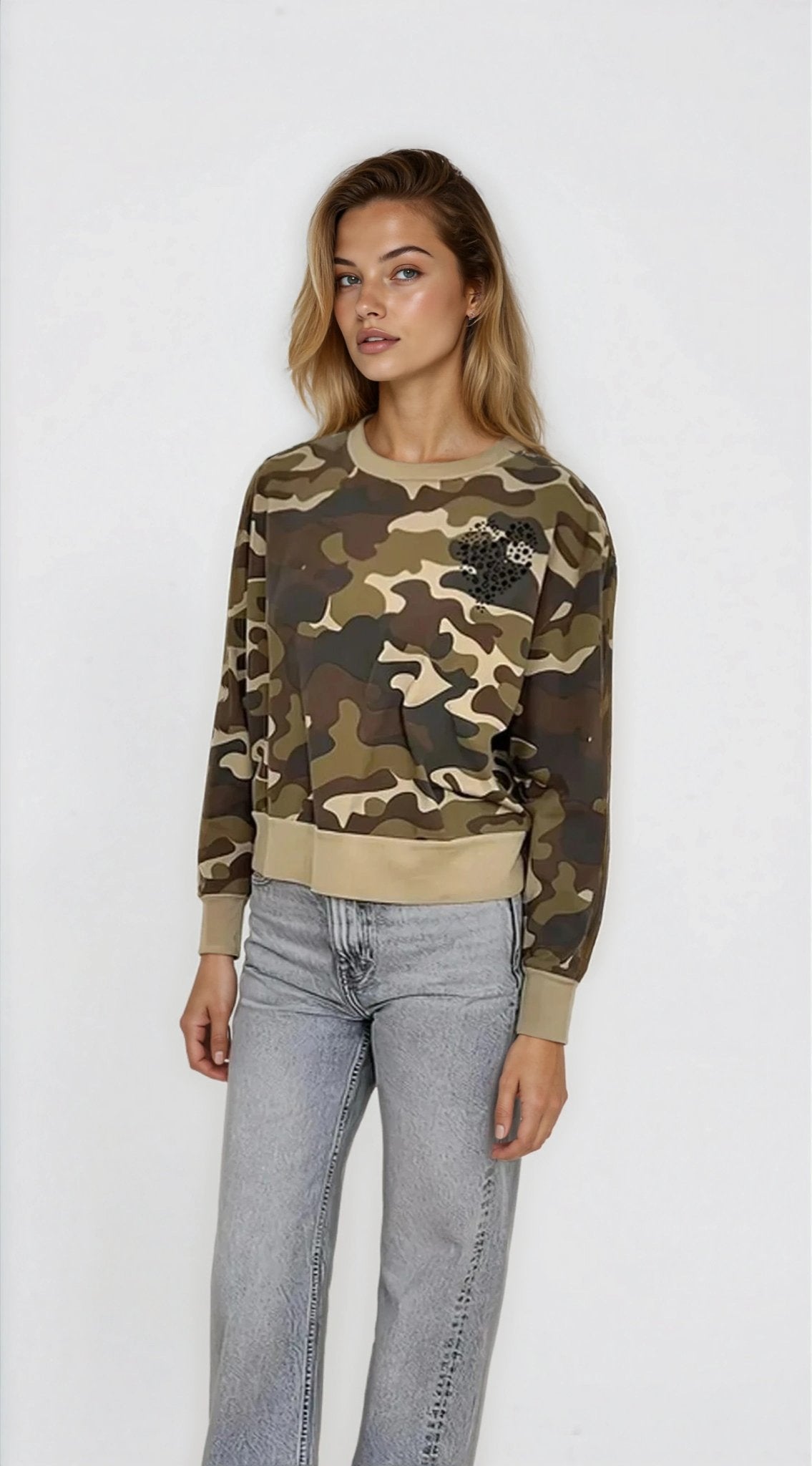 Woman wearing a camouflage sweater and jeans on a white background