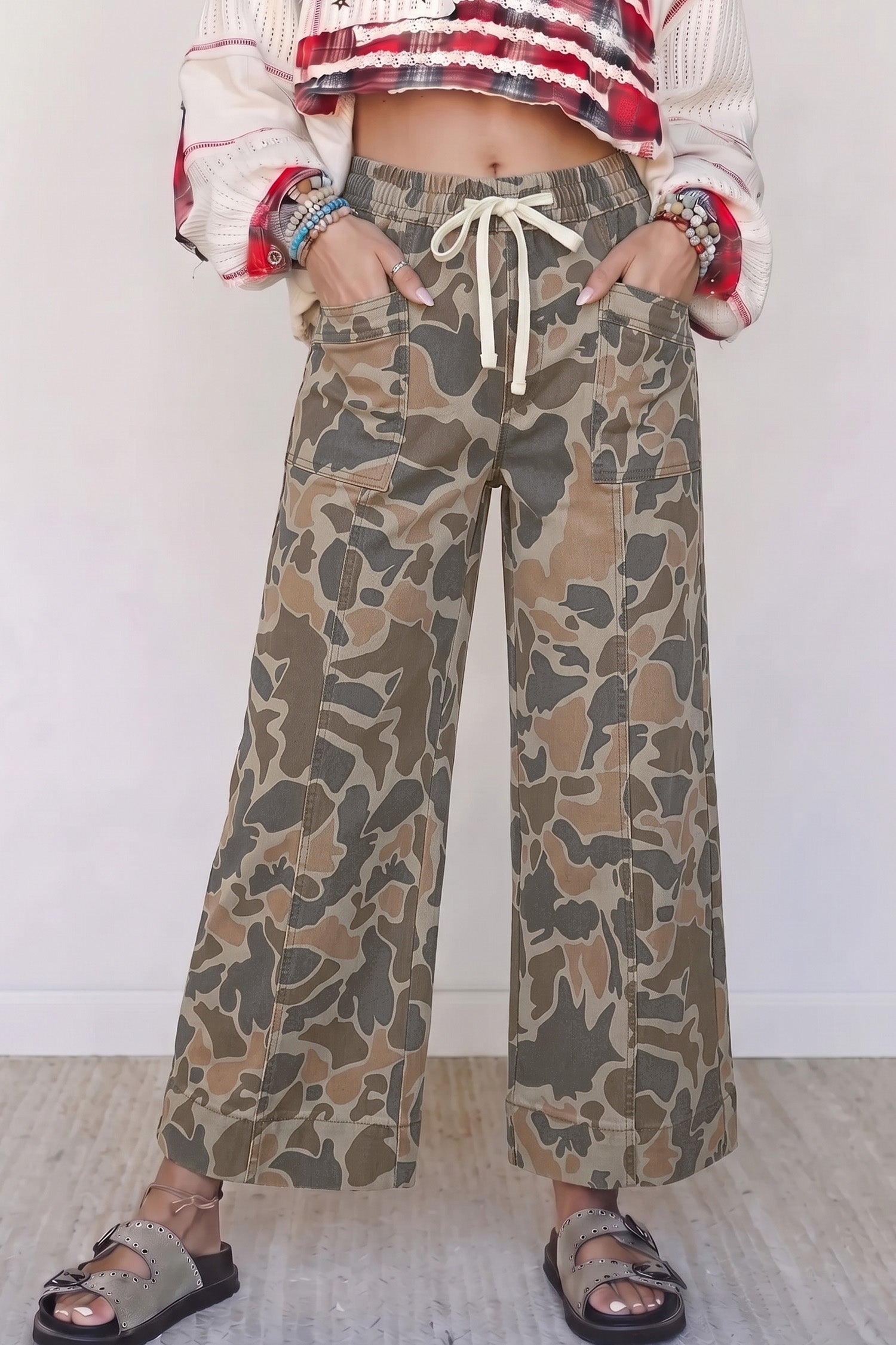 Women's camo print drawstring waist wide leg jeans with patch pockets and sandals, front view