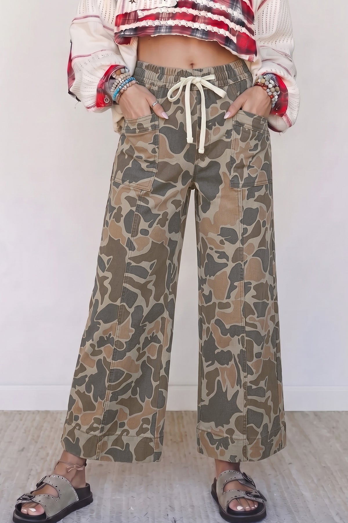 Women's camo print drawstring waist wide leg jeans with patch pockets and sandals, front view