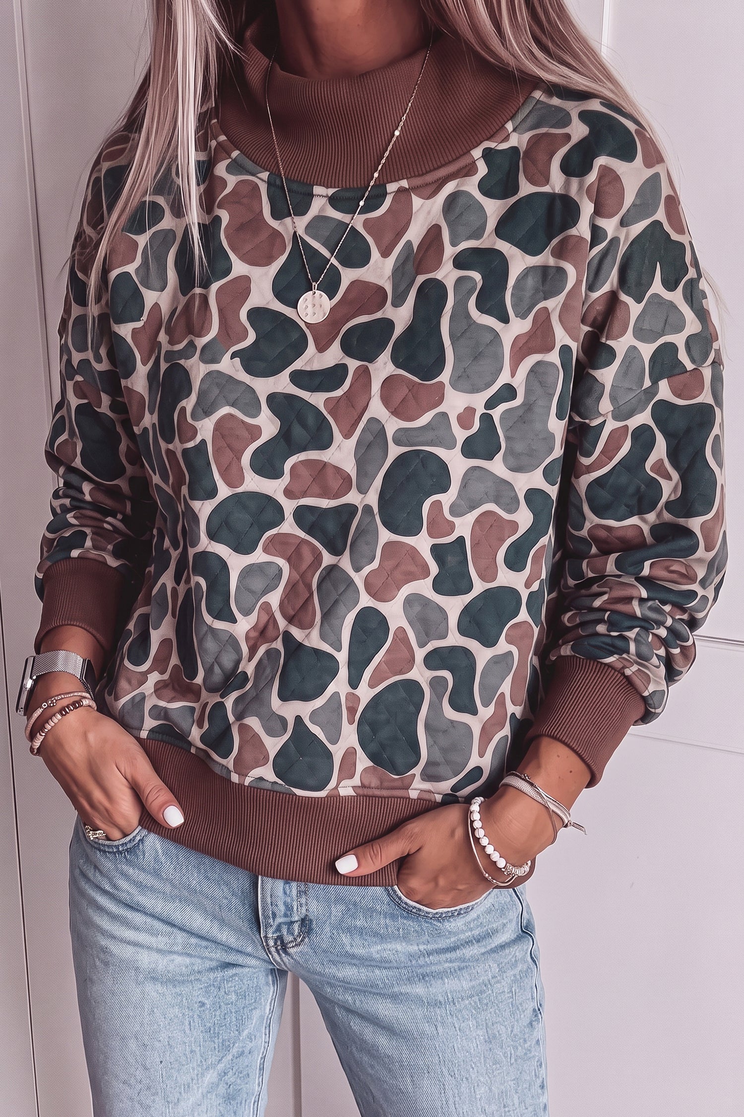 Green and brown camo mock neck pullover styled with light-wash jeans