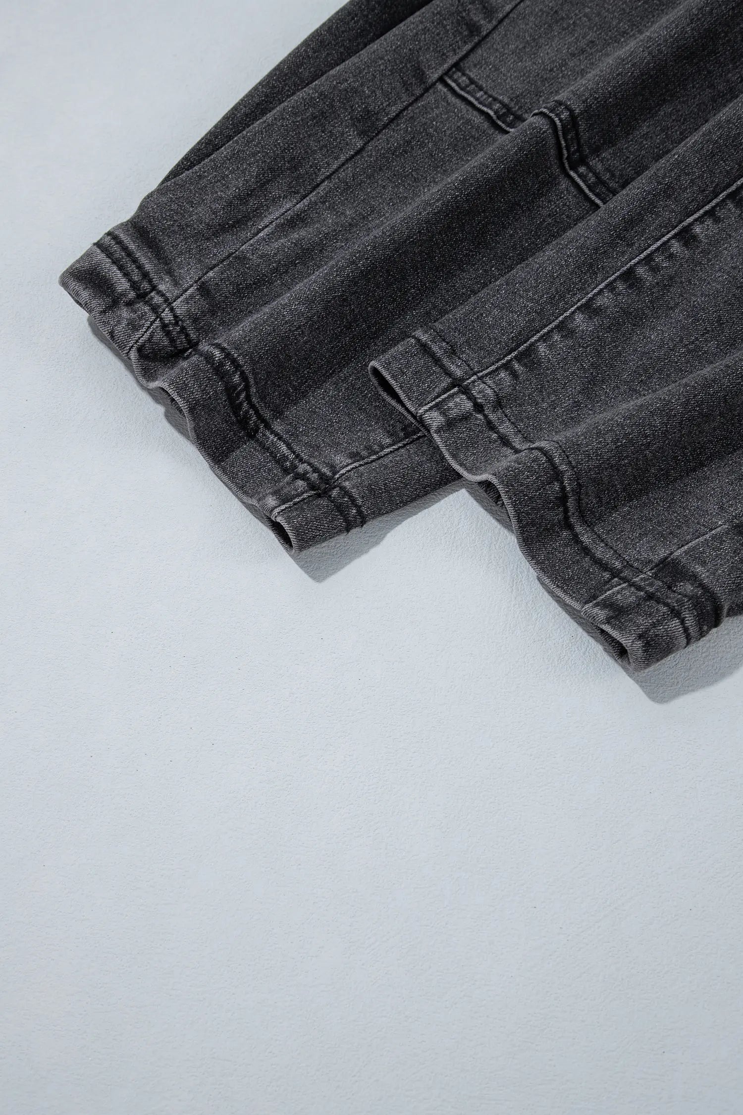 Close-up of hem and seam stitching on carbon grey barrel leg jeans