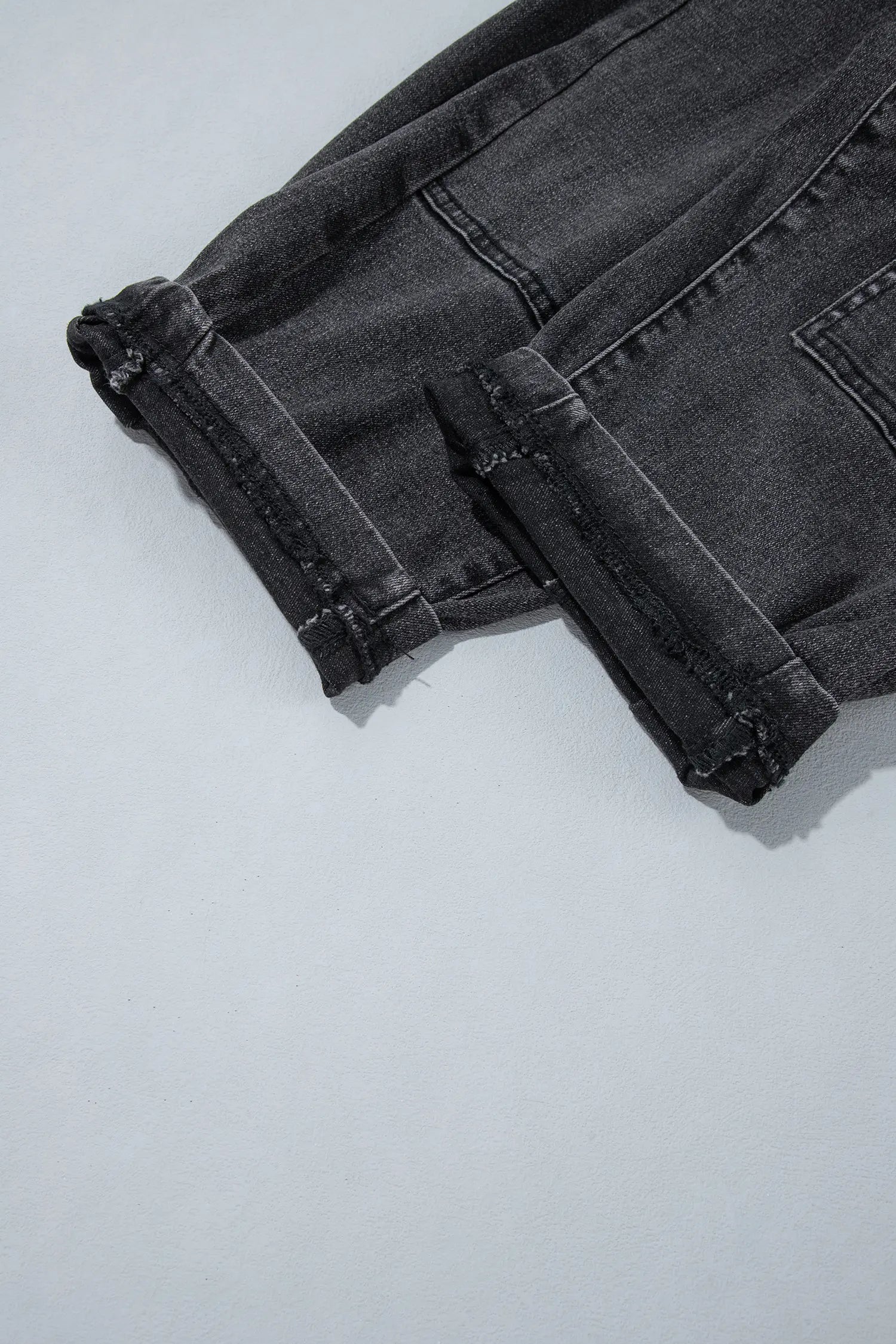 Close-up of leg seams and hem on carbon grey patchwork jeans