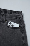 Close-up of front pocket holding a phone on carbon grey jeans