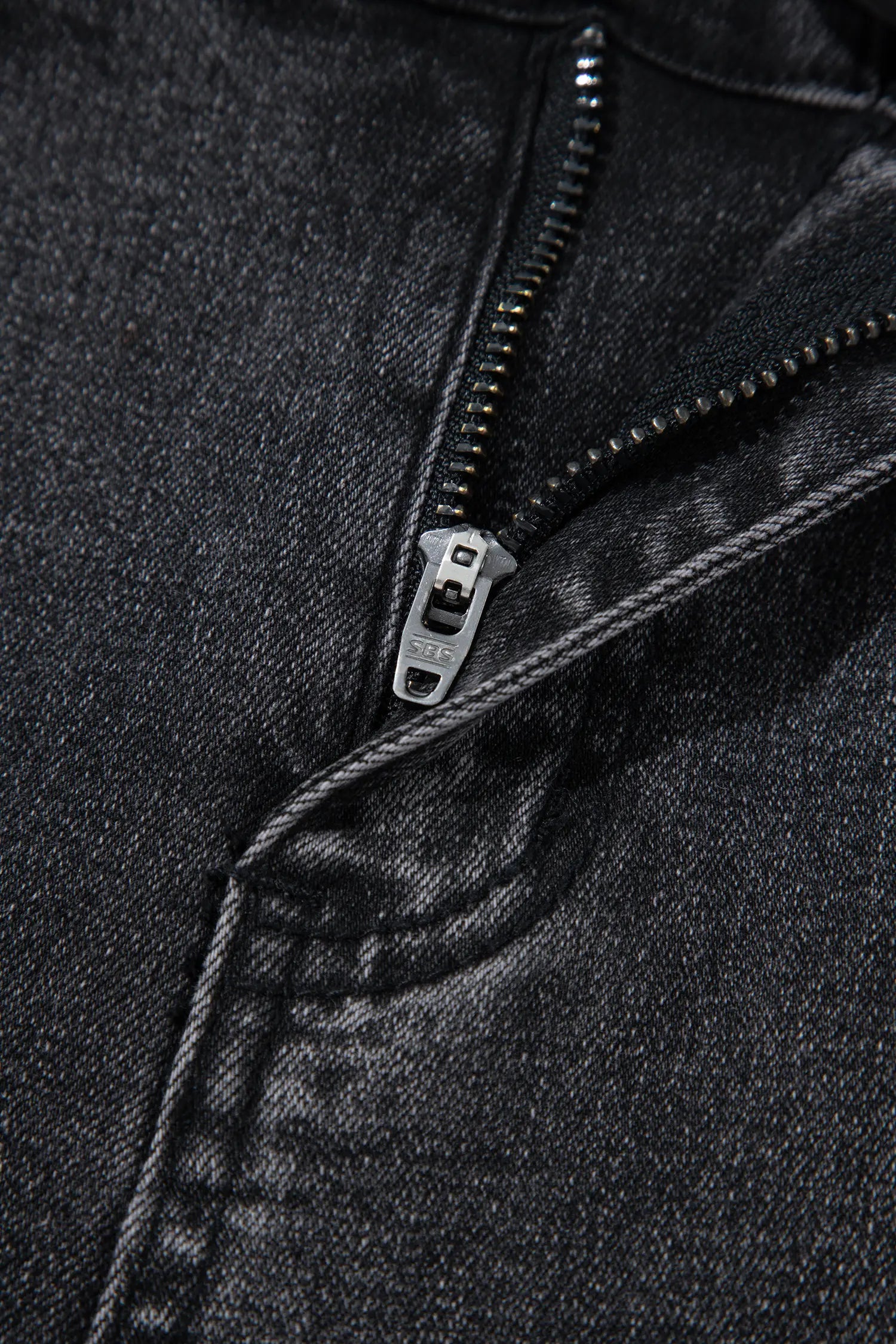 Close-up of metal zip fly on carbon grey barrel leg jeans