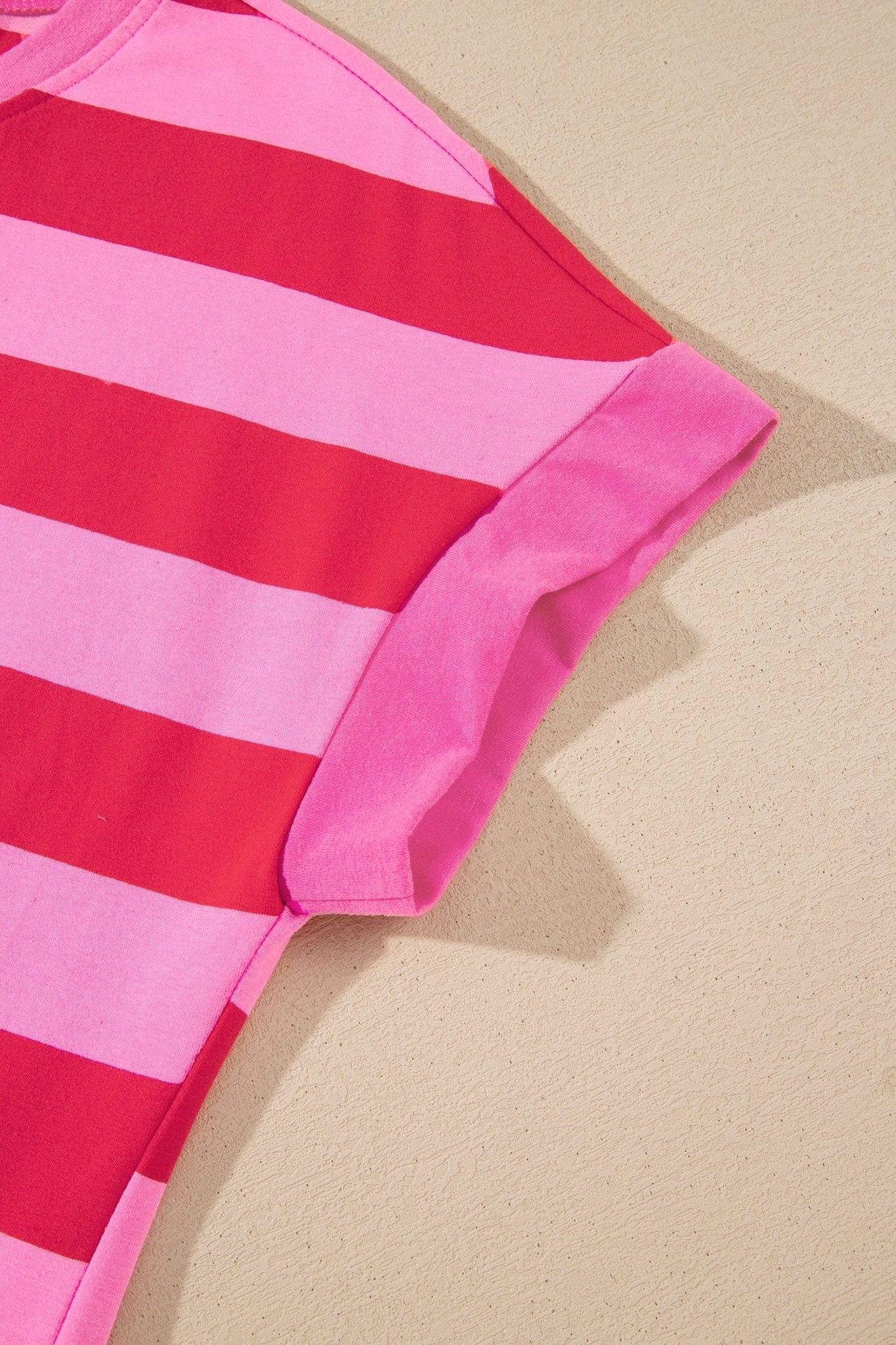 Close-up of a pink and red striped short-sleeve top with cuff.