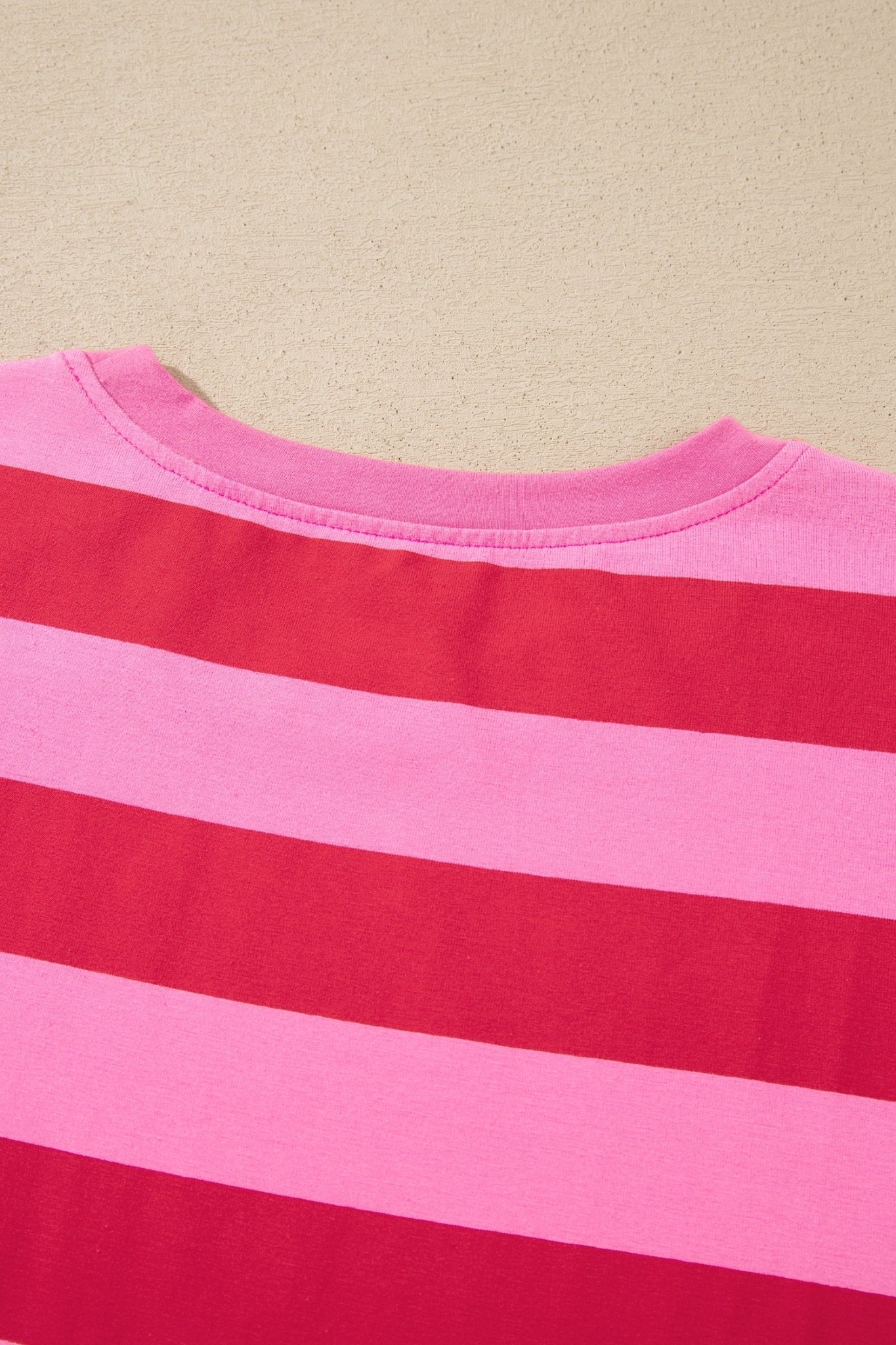 Close-up of a pink and red striped t-shirt showing the back collar.
