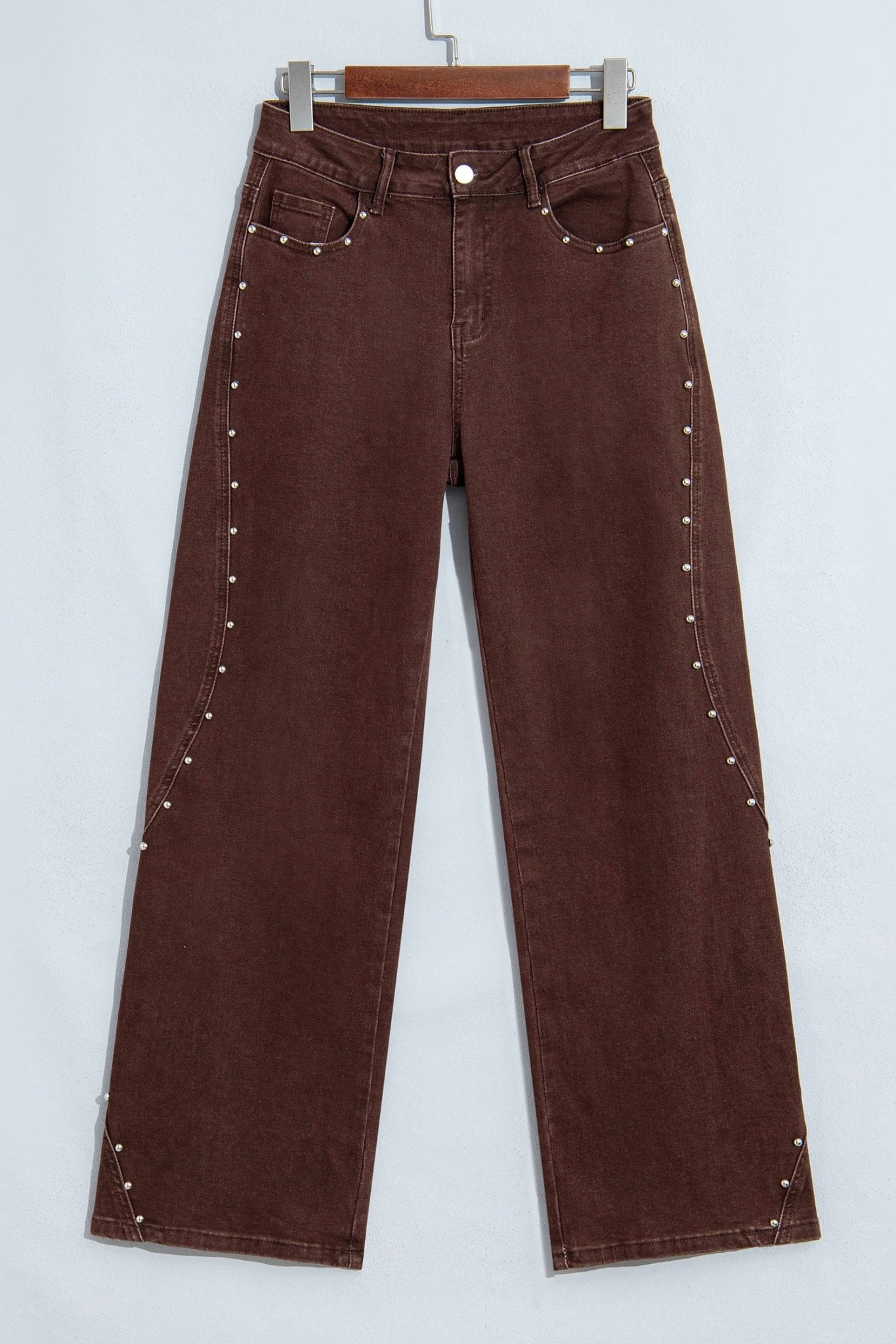 Close-up back view of dark brown jeans with waistband, belt loops, and back pockets.