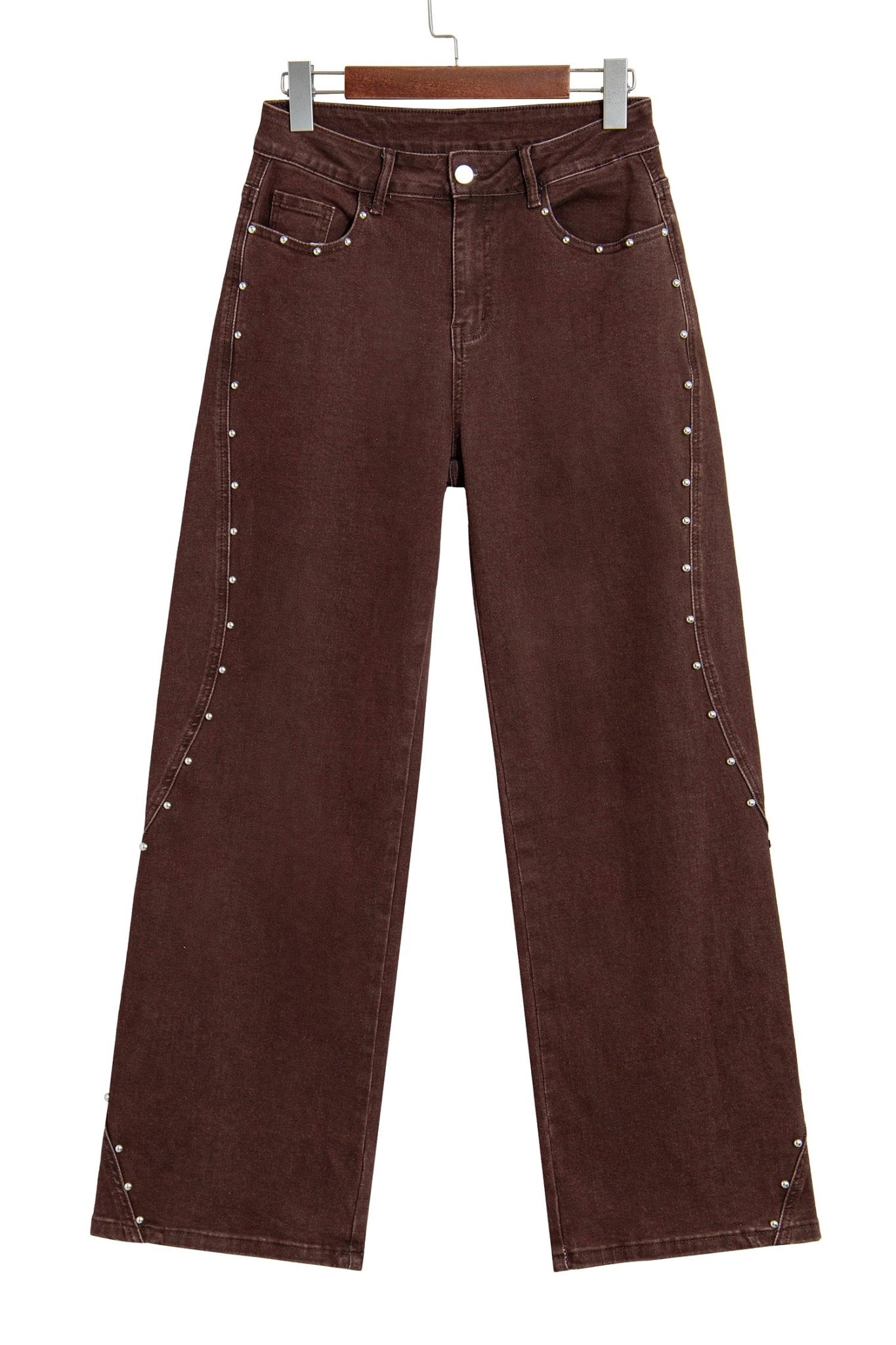 Dark brown wide-leg jeans with silver studs along the seams on a wooden hanger