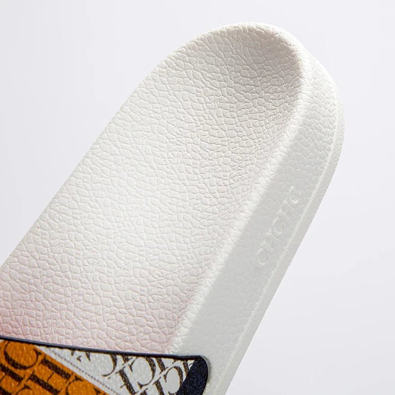 Close-up of a white sandal with a brand logo on a light gray background