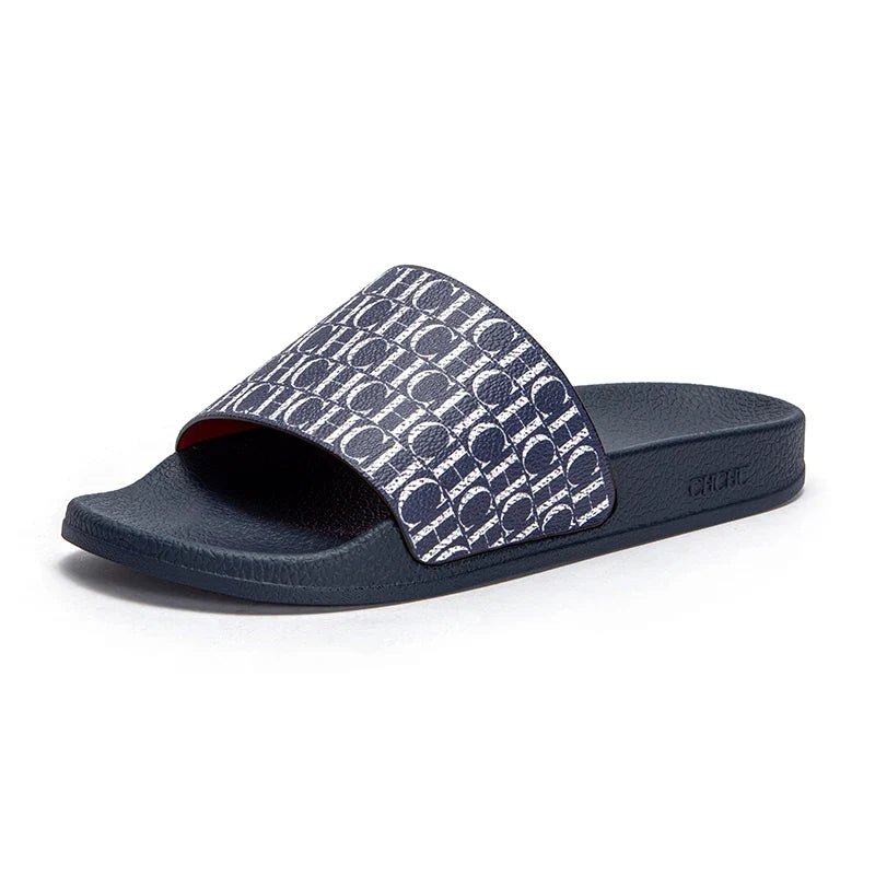 Navy slide sandal with patterned strap on a white background