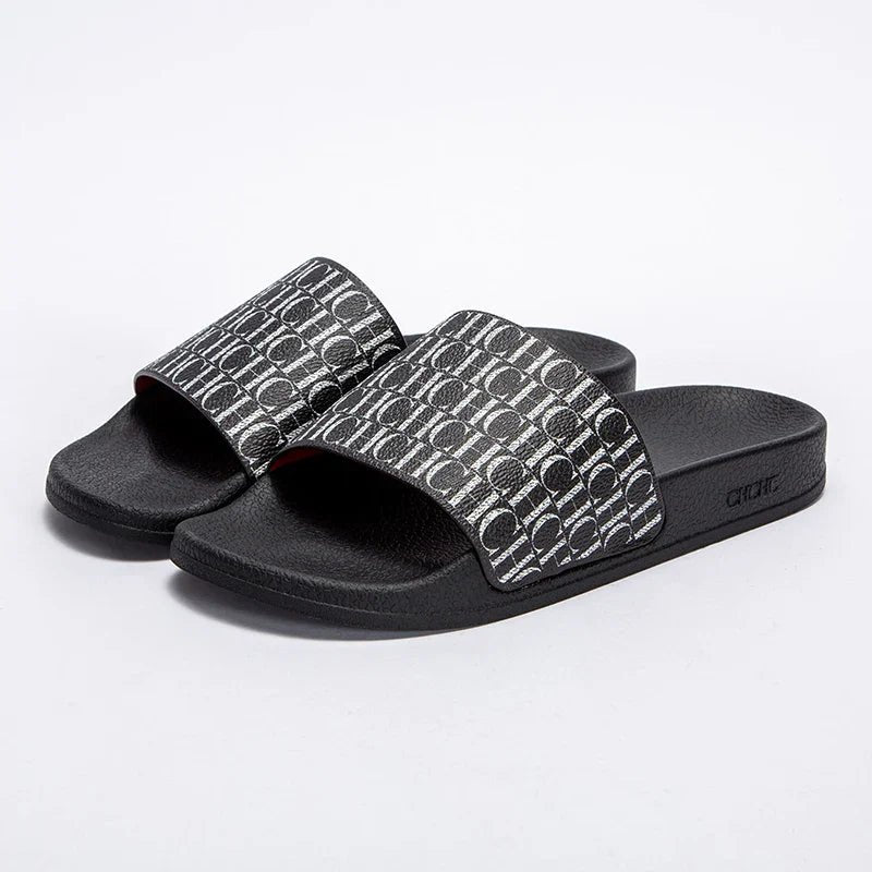 Black slides with patterned straps on a white background