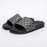 Black slides with patterned straps on a white background