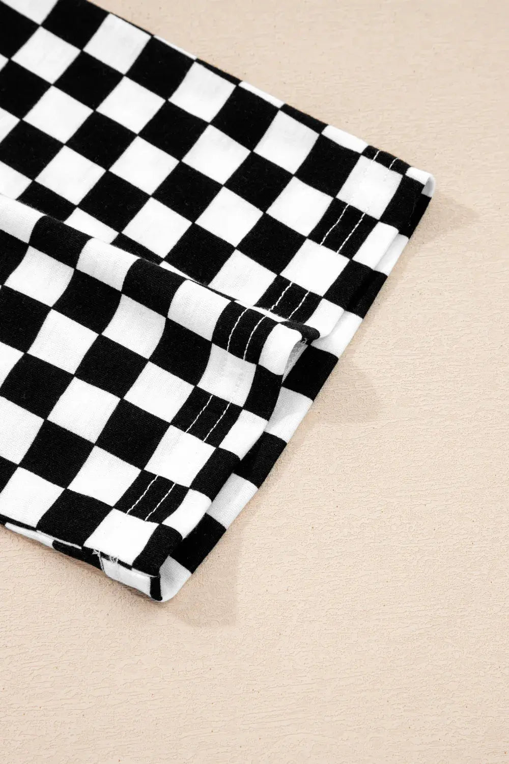 Black and white checkered fabric on a beige background