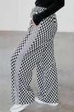 Checkered pants with gray side strip worn by a person on a plain background