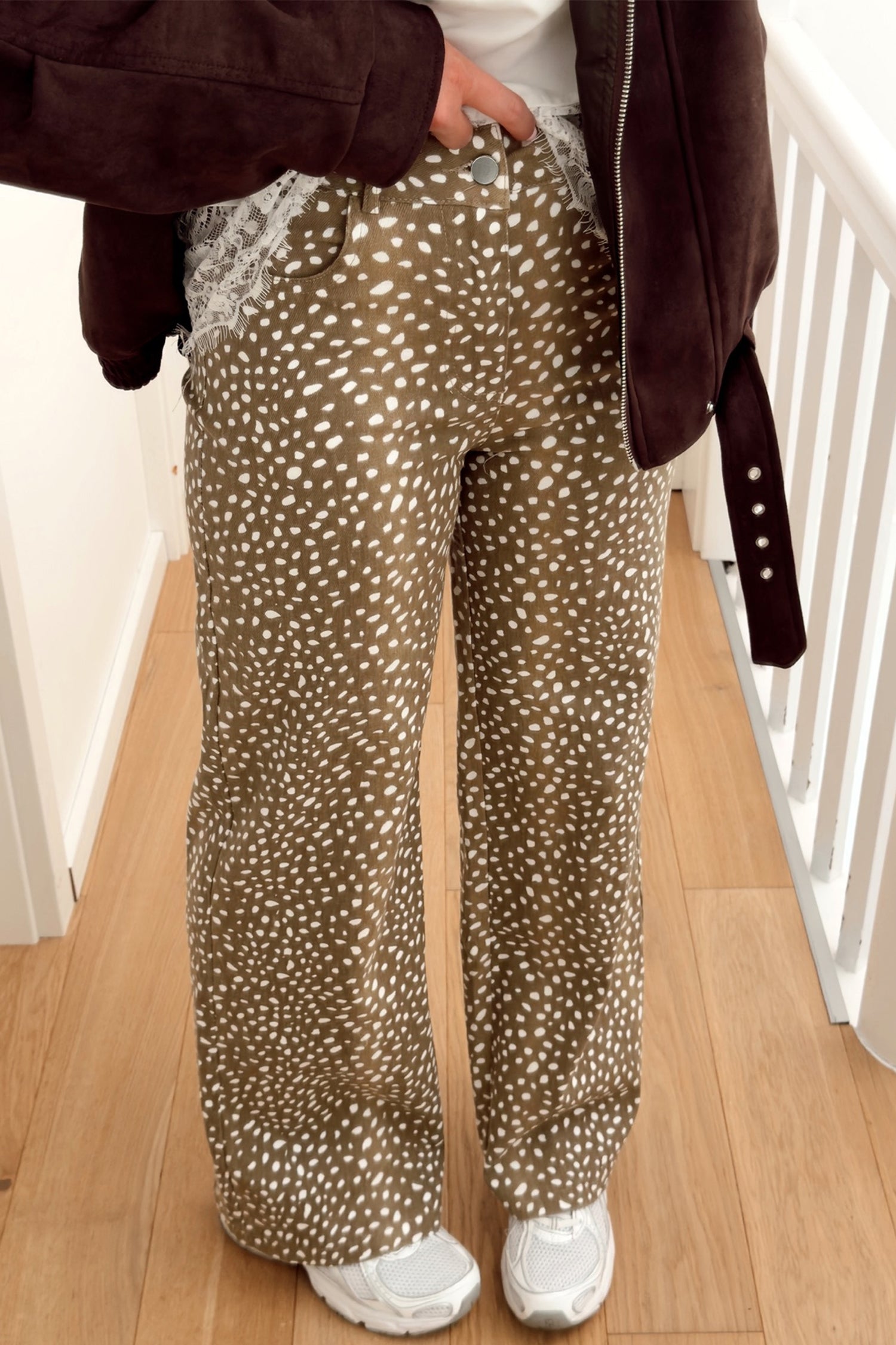 Women's brown cheetah print high waist wide leg jeans with suede jacket and sneakers, front view