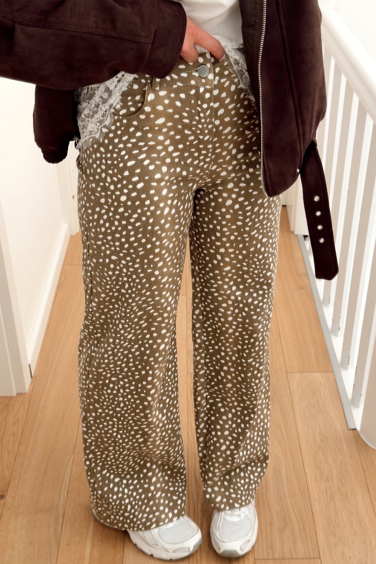 Women's brown cheetah print high waist wide leg jeans with suede jacket and sneakers, front view