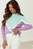 Woman wearing a colorful sweater with a plain background