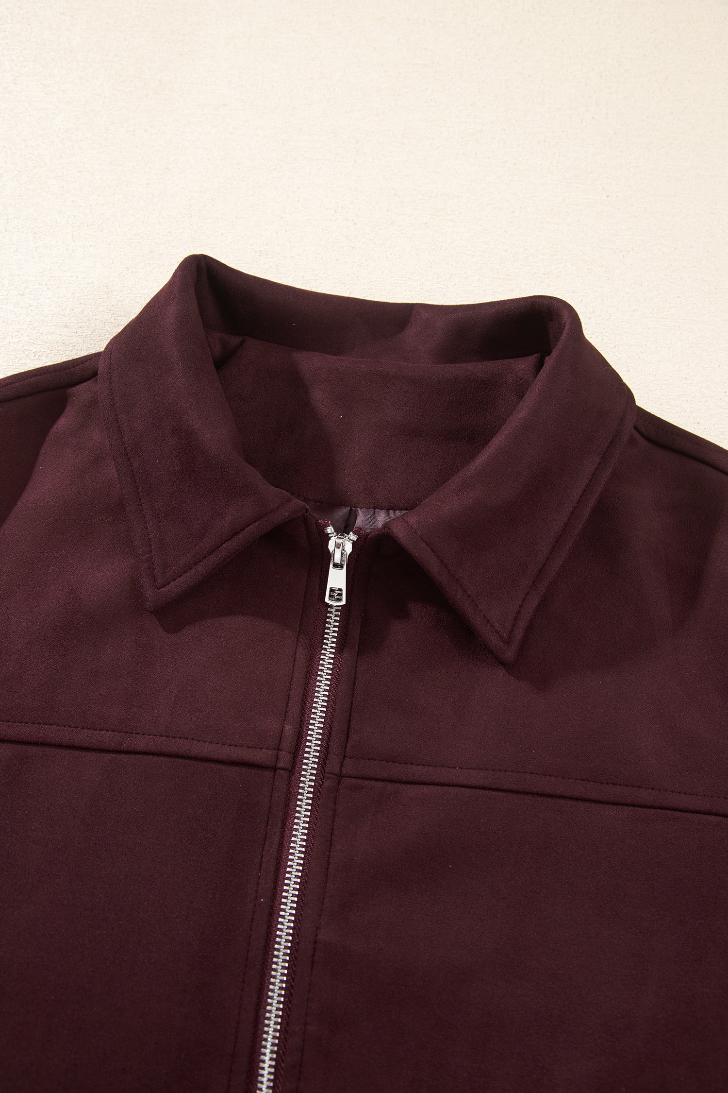 Close-up of pointed collar and metal zipper on chicory coffee suede look bomber jacket