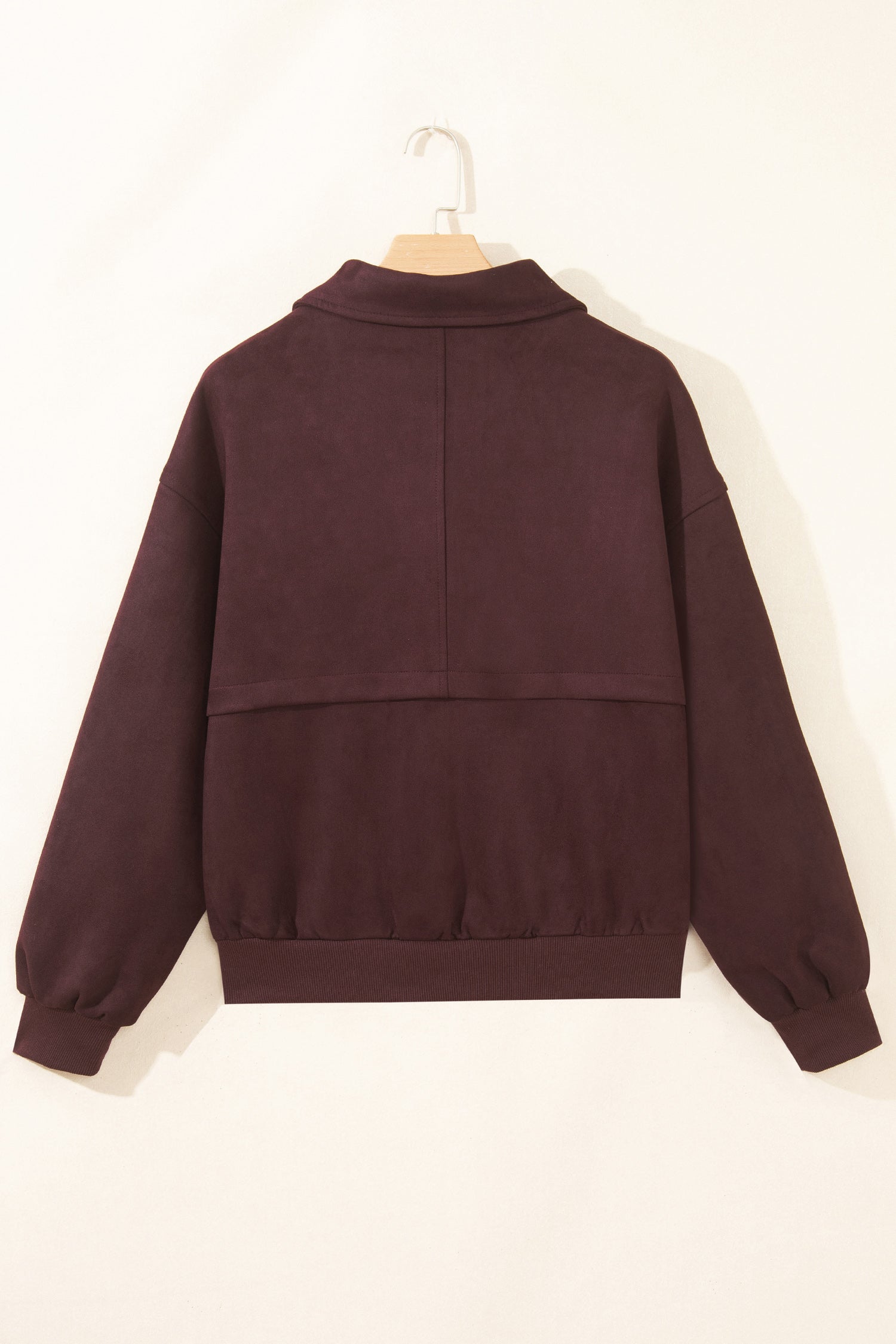 Back of chicory coffee suede look bomber jacket on a hanger with center seam and ribbed hem