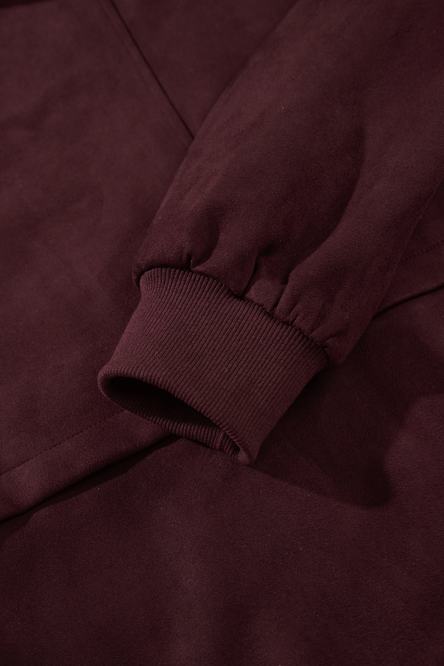 Close-up of ribbed cuff on chicory coffee suede look bomber jacket sleeve