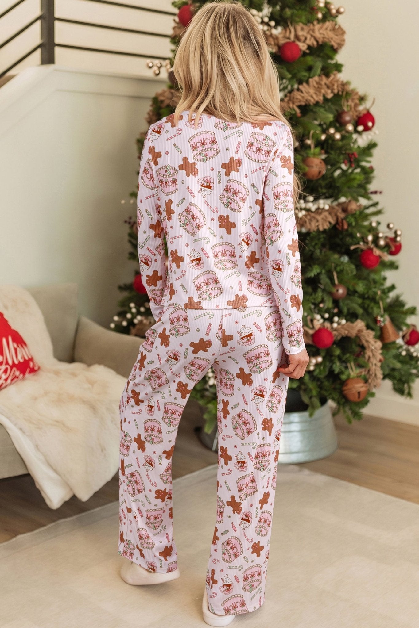 Back view of woman in long-sleeve pajamas with allover Christmas print.