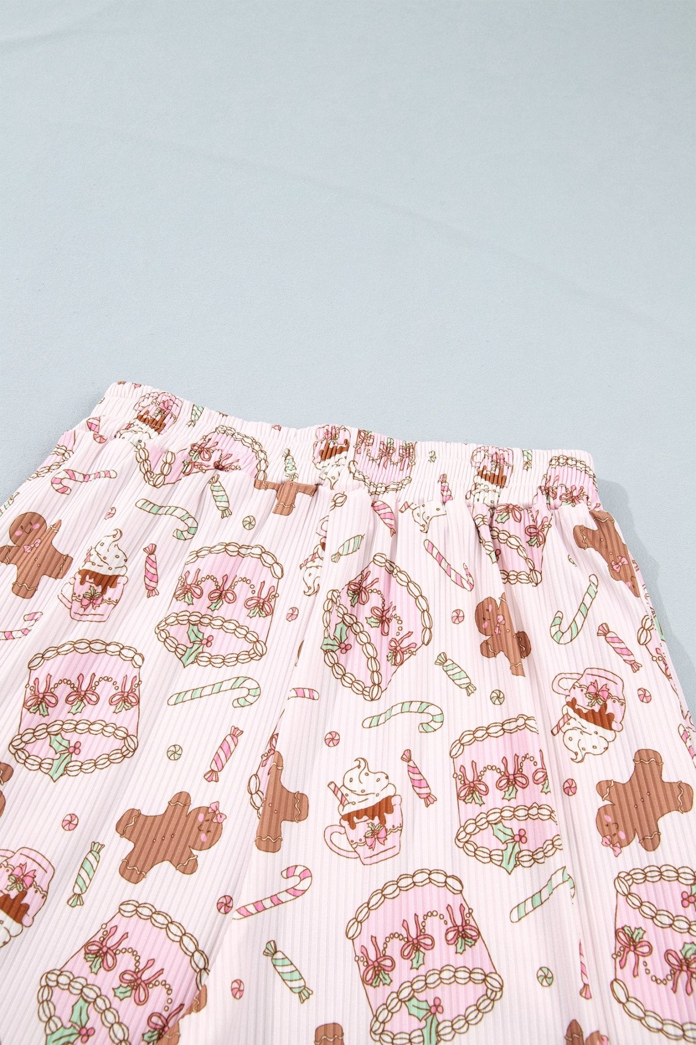 Pink ruffled fabric with gingerbread, cupcake, and candy cane print.
