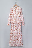 White pajamas with gingerbread, hearts, and “Candy” print on wooden hanger.