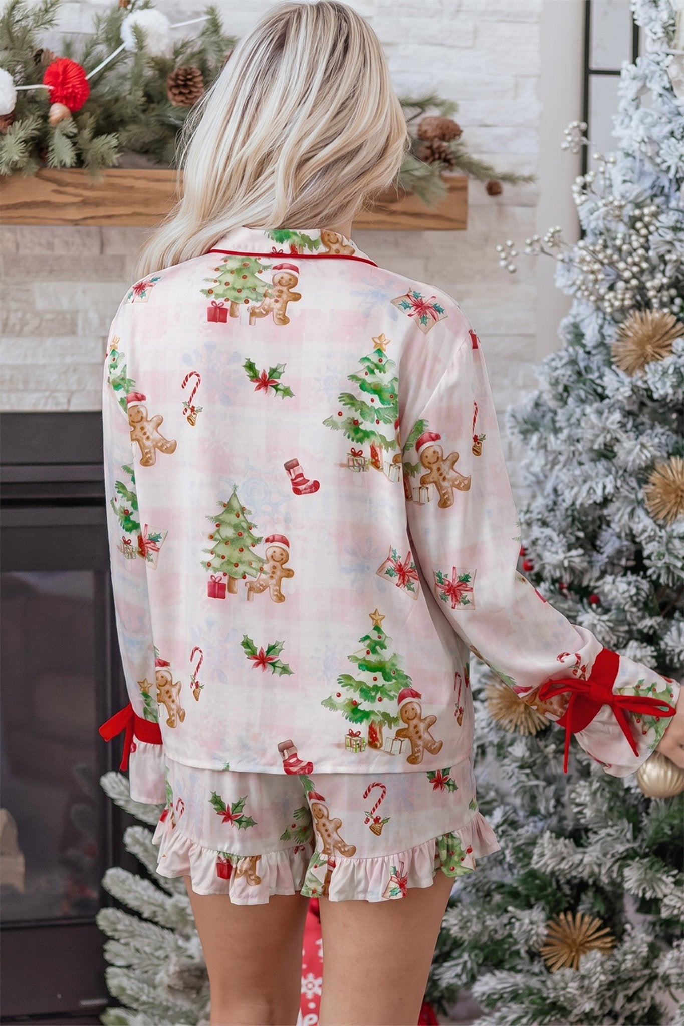 Woman wearing light pink Christmas pajamas with gingerbread and candy cane print.