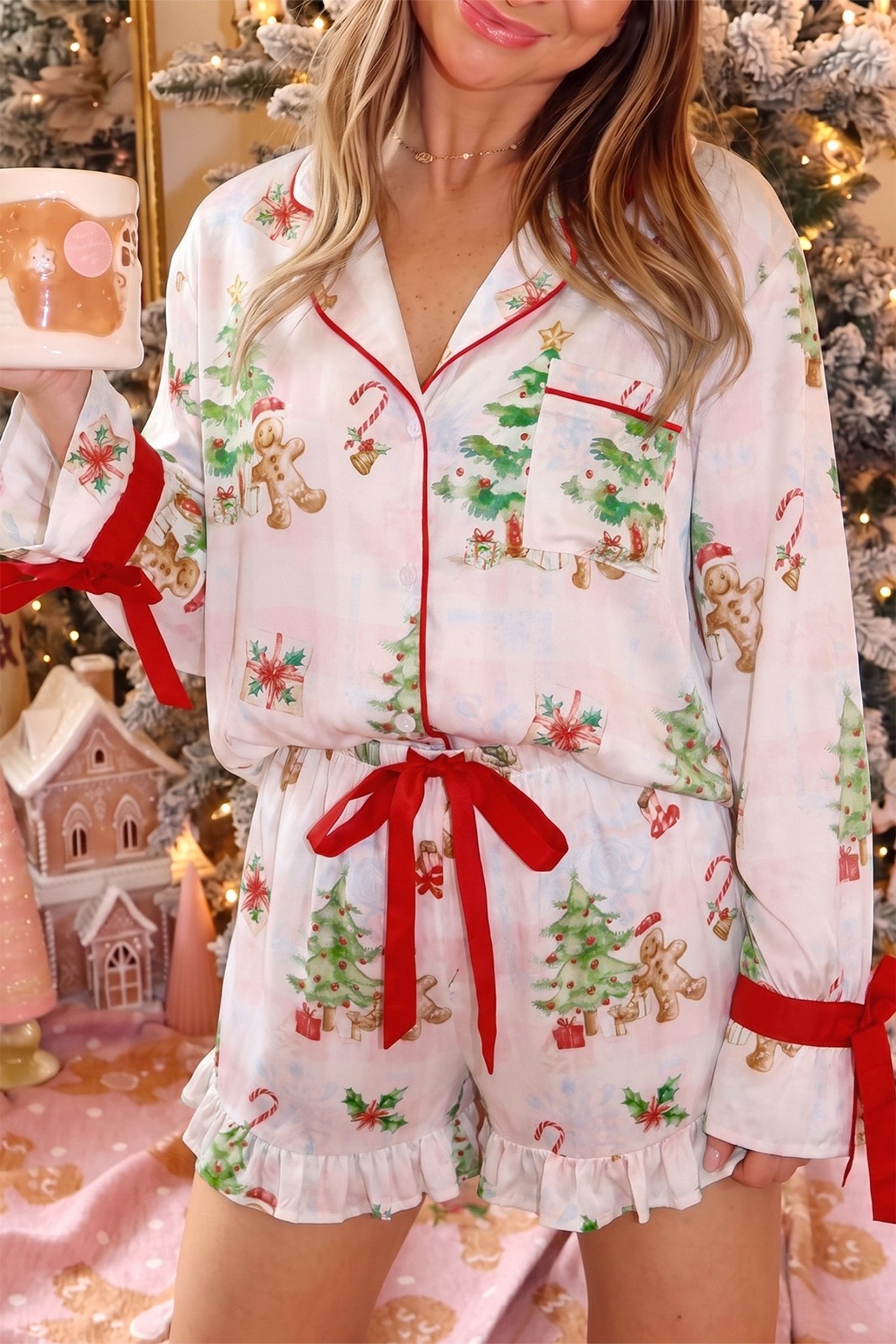Woman wearing white Christmas pajamas with red trim and holiday print.