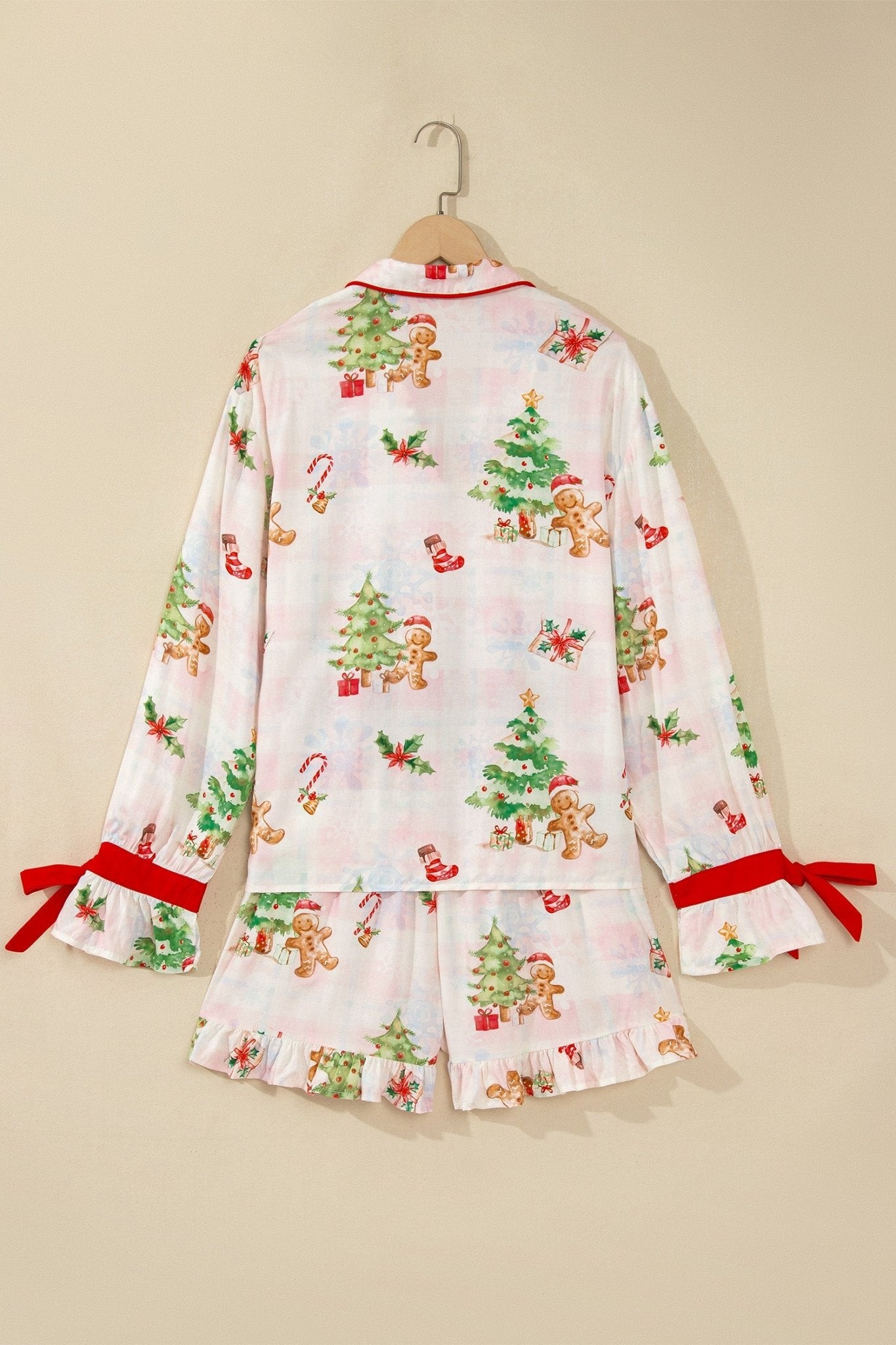 White Christmas pajama set with gingerbread print and red ribbon ties.