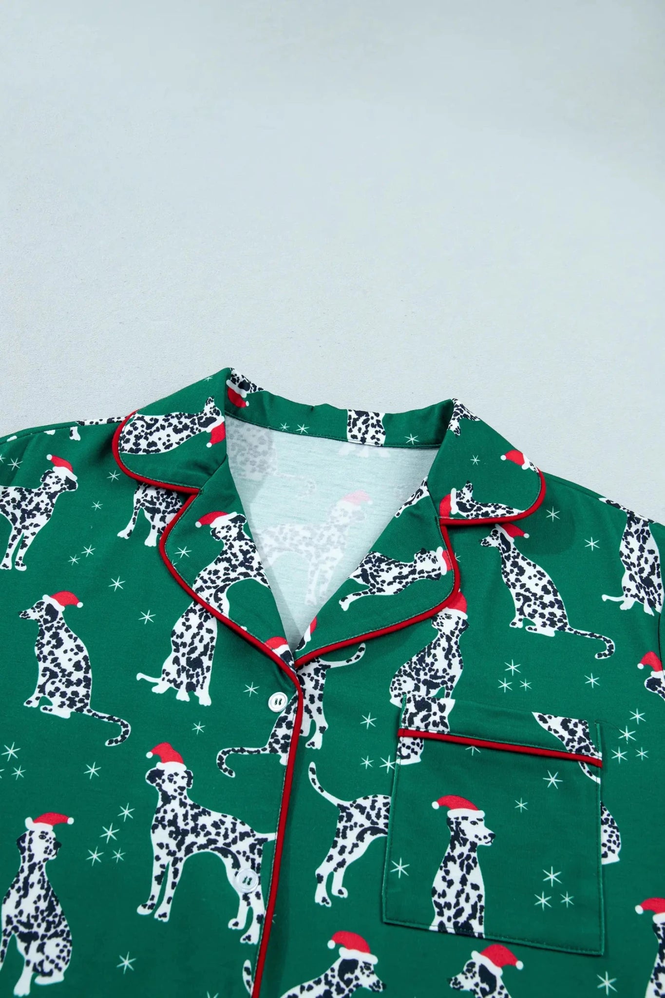 Green Dalmatian pajama top with Santa hats and red piping.