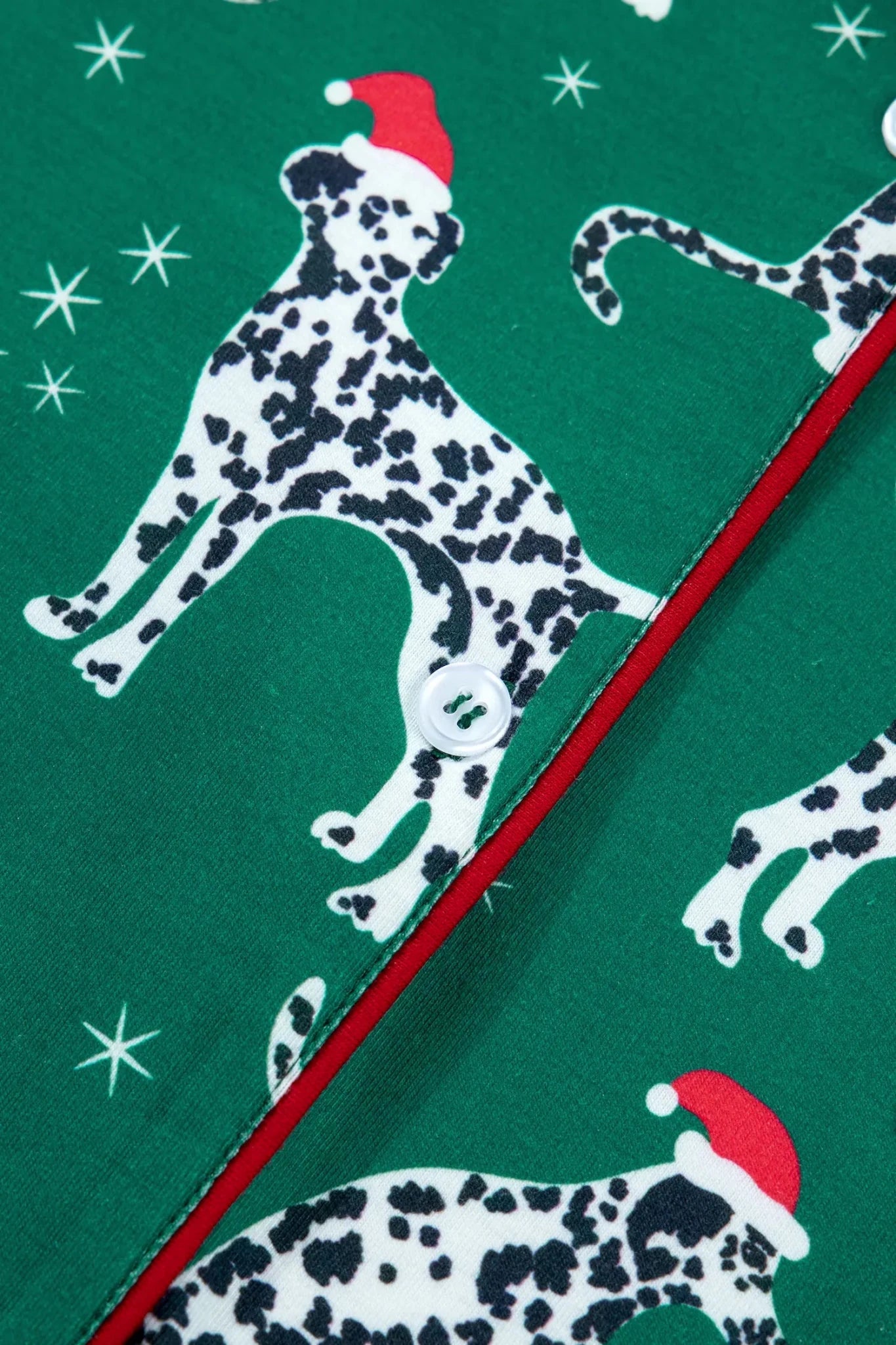Green fabric with Dalmatian dogs in Santa hats, stars, and red trim.