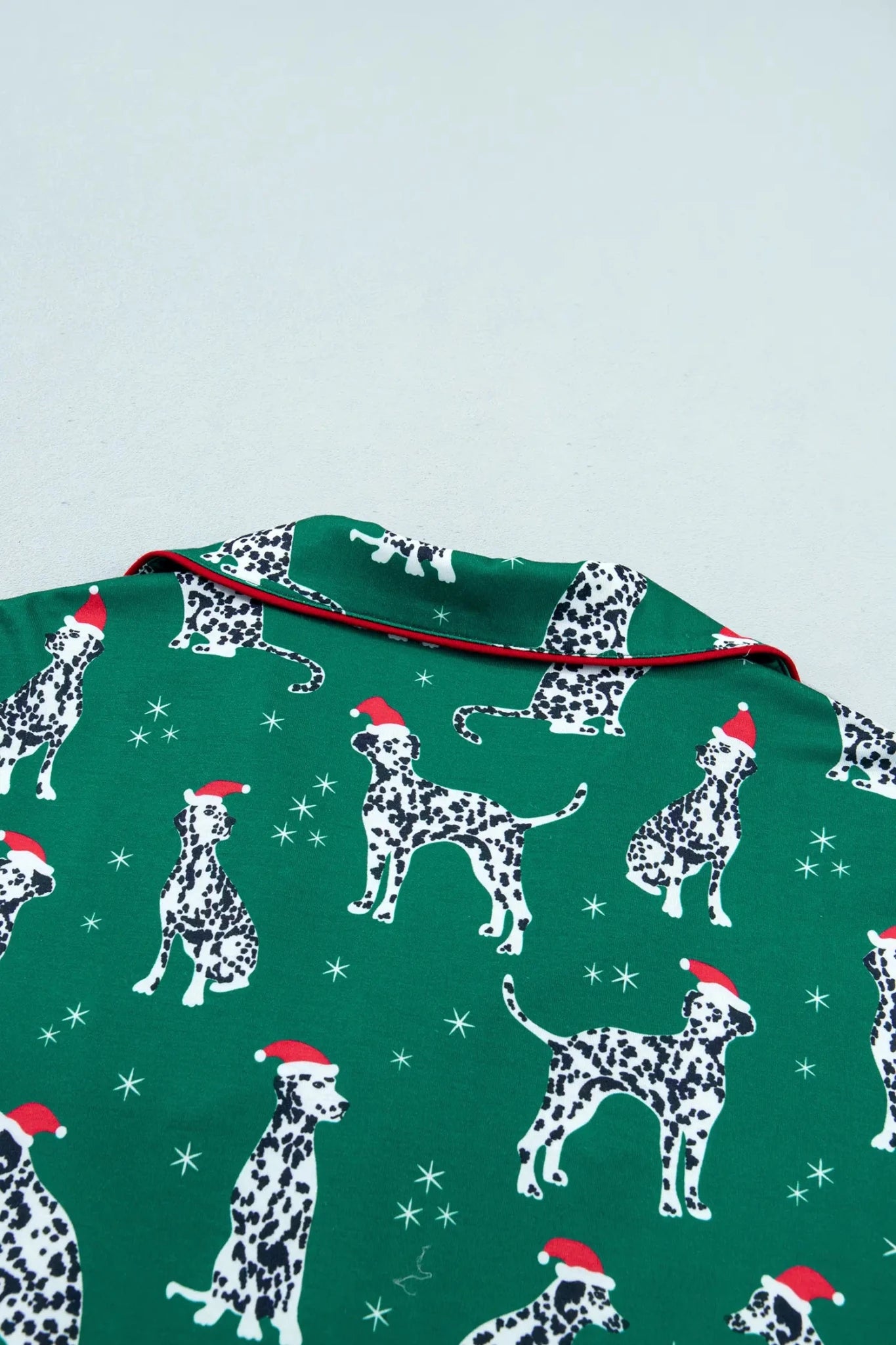 Green Dalmatian pajama fabric with Santa hats and red piping.