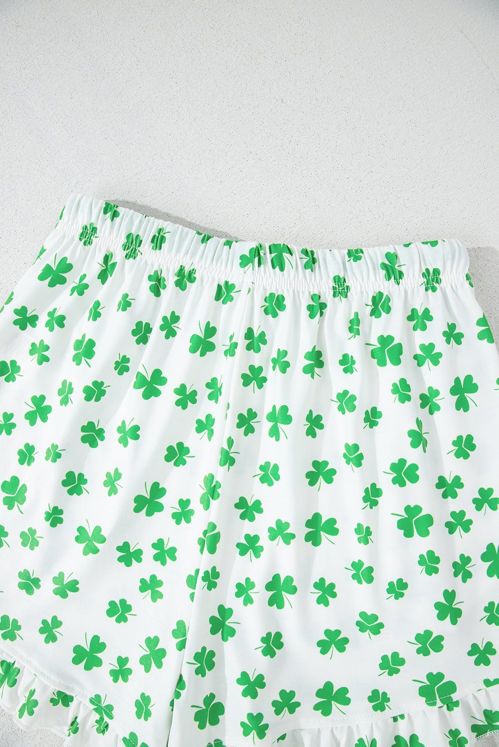 Green shamrock pattern on white fabric