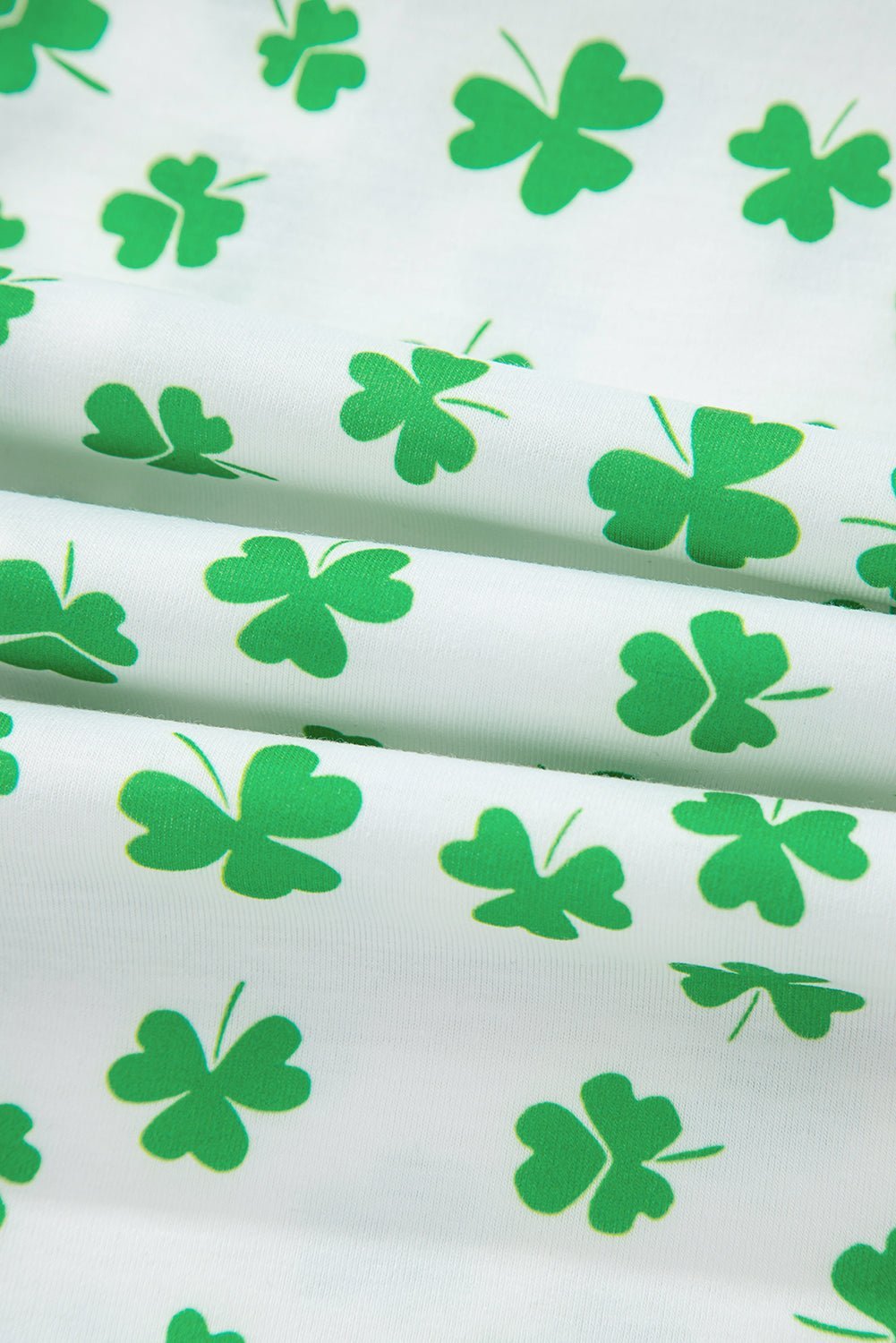 Green clover pattern on white fabric