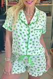 Woman wearing a green and white shamrock patterned romper in an indoor setting.