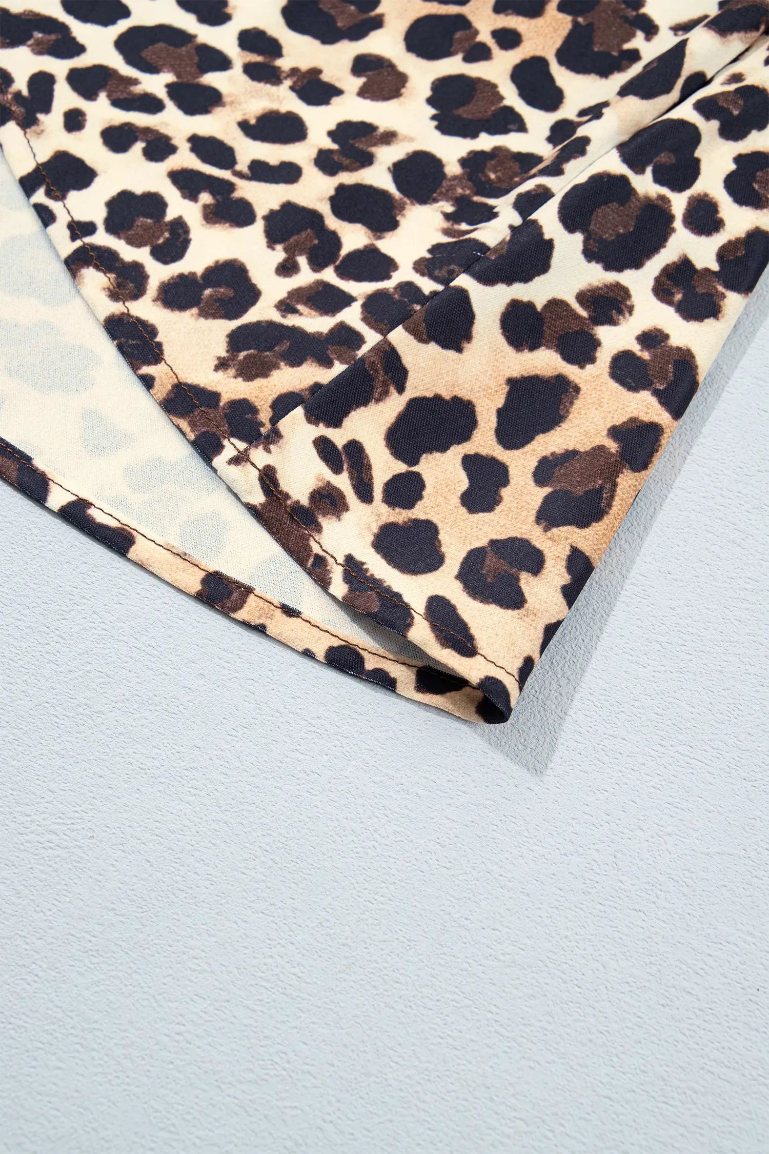 Close-up of leopard print ruffle hem on coffee mini dress