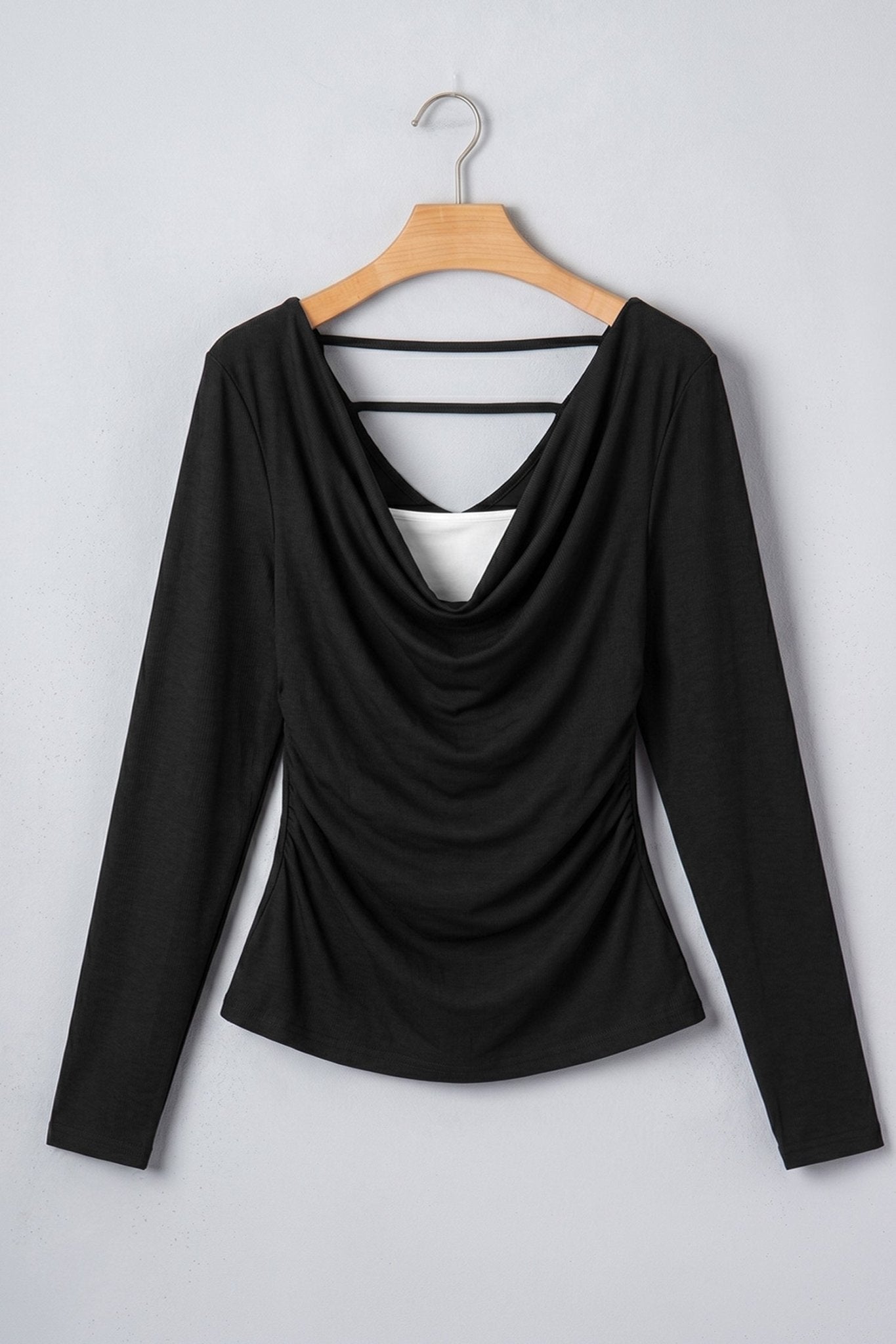 Black long-sleeve cowl-neck top with double back straps on wooden hanger.