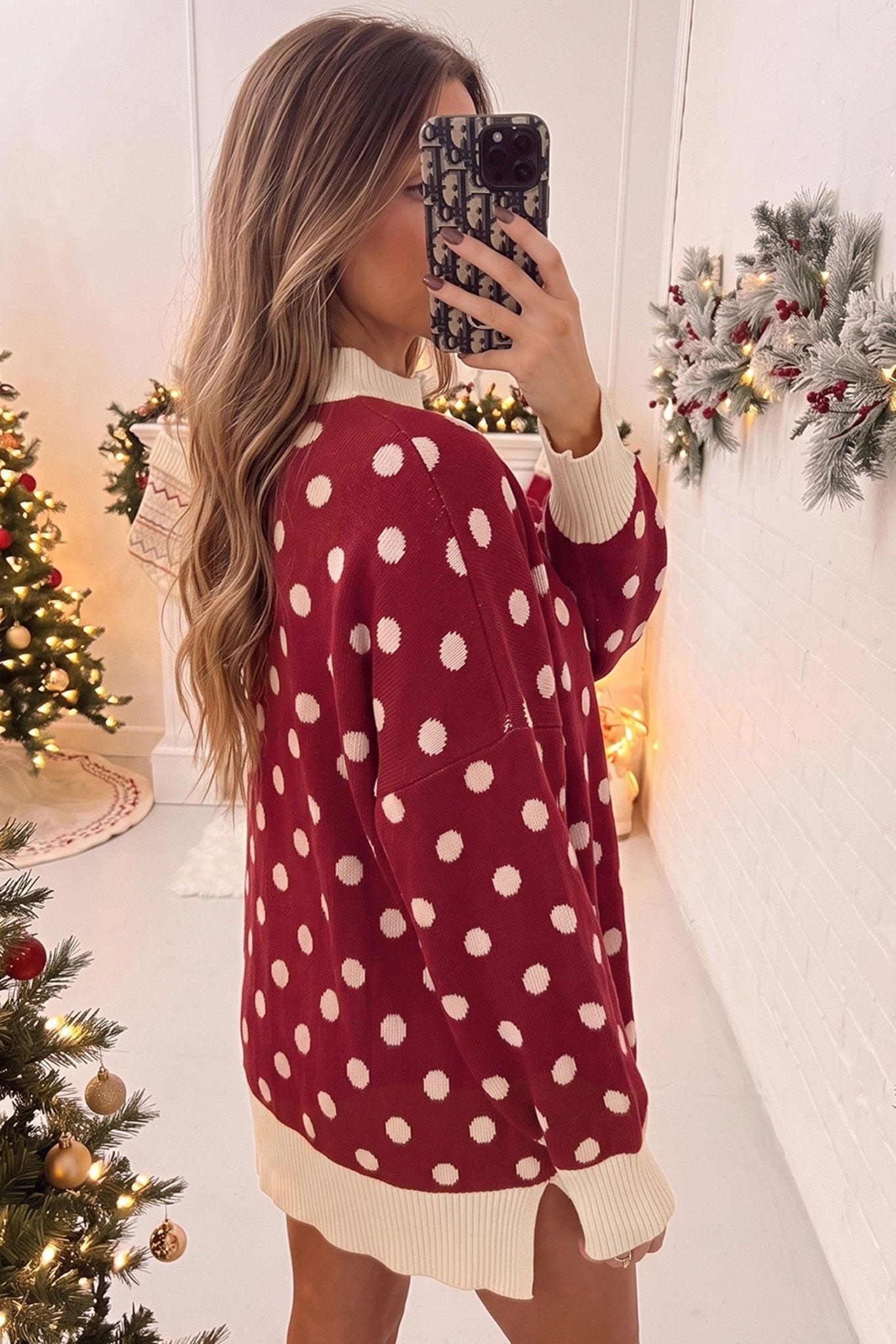 Woman in oversized red sweater with cream polka dots and ribbed trim