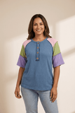 Woman wearing a colorful shirt with a plain background